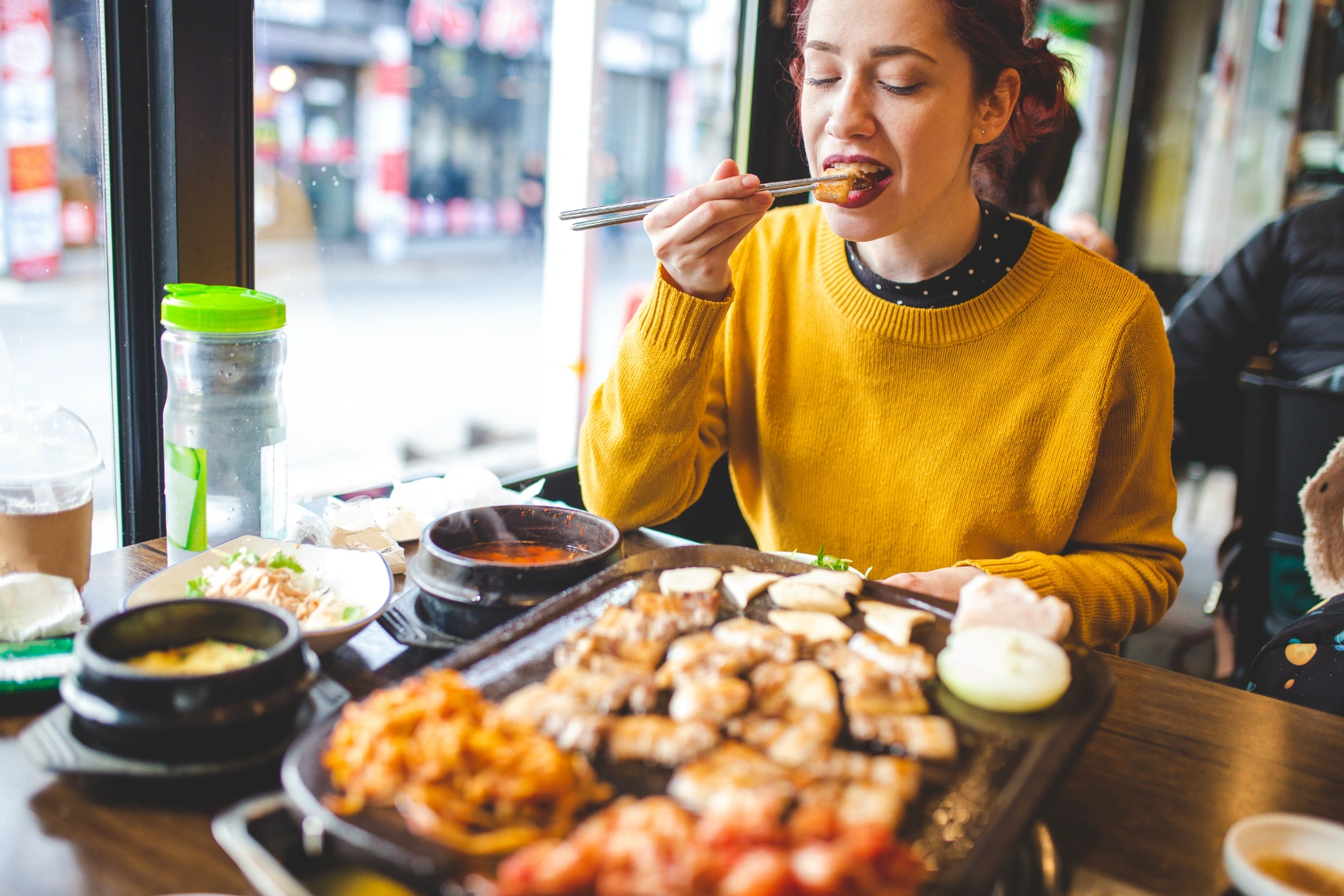 A woman traveller eats South Korean food at a restaurant