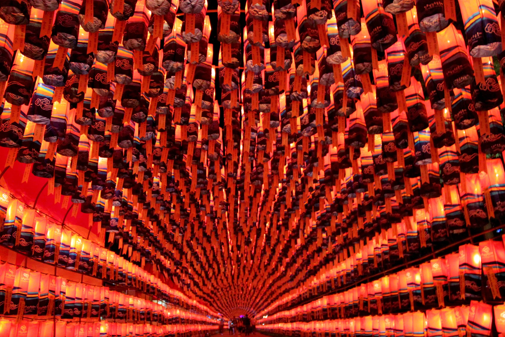 People walk through a tunnel of red lanterns at the Seoul Lantern Festival in South Korea