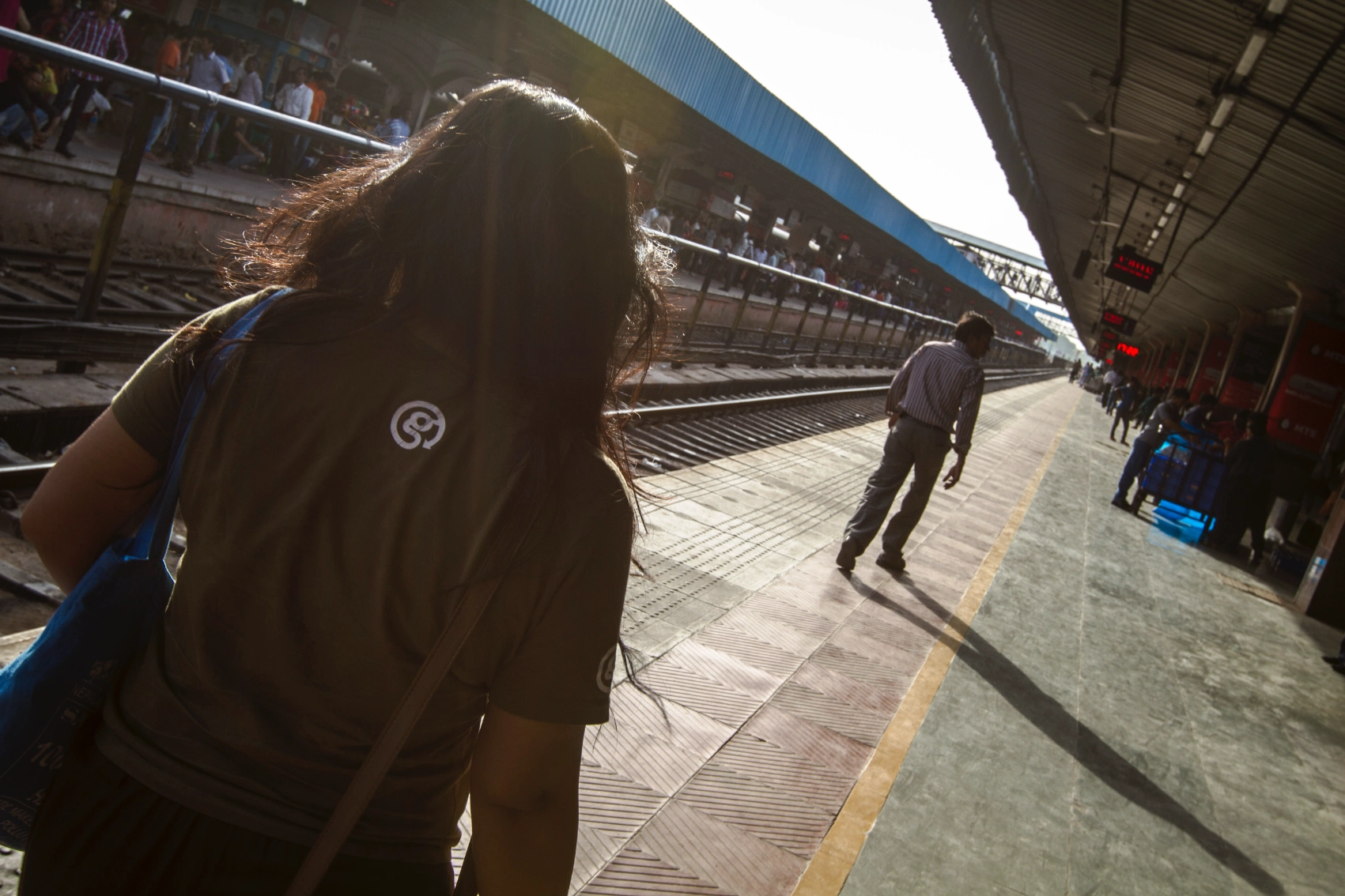 A woman traveller walks along the train platform at Delhi's railway station
