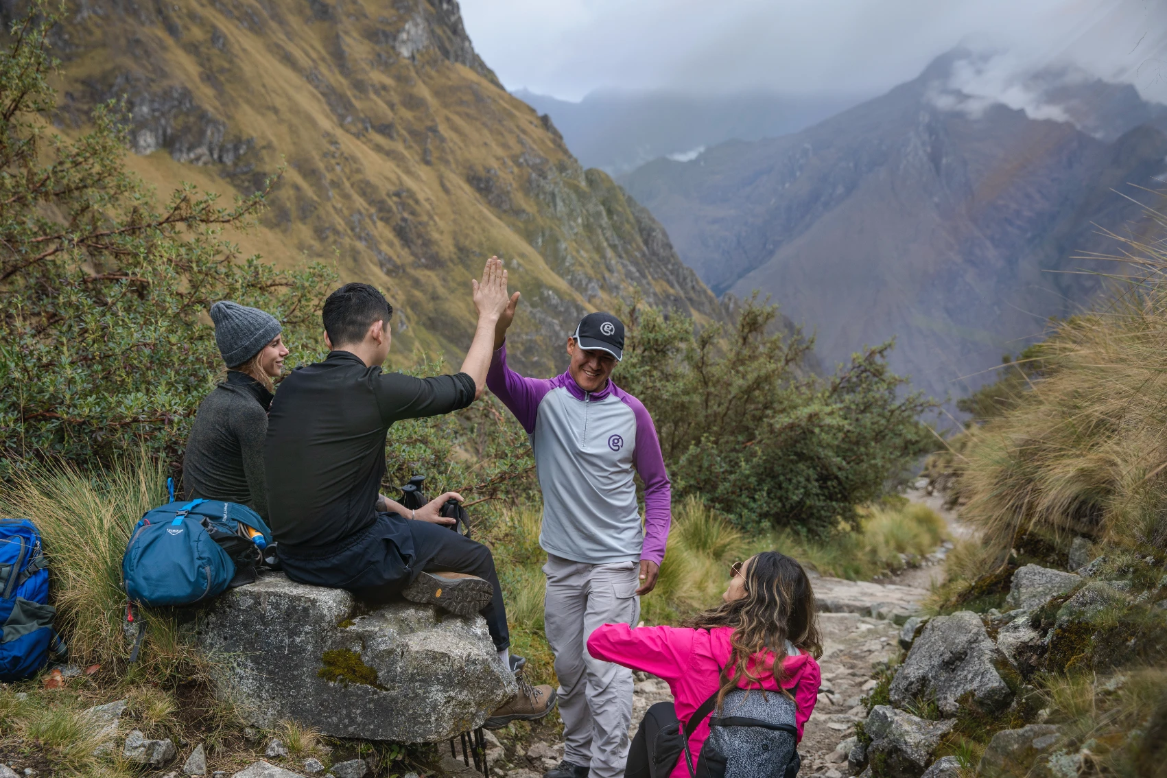 A group of travellers high-fives on the Inca Trail in Peru
