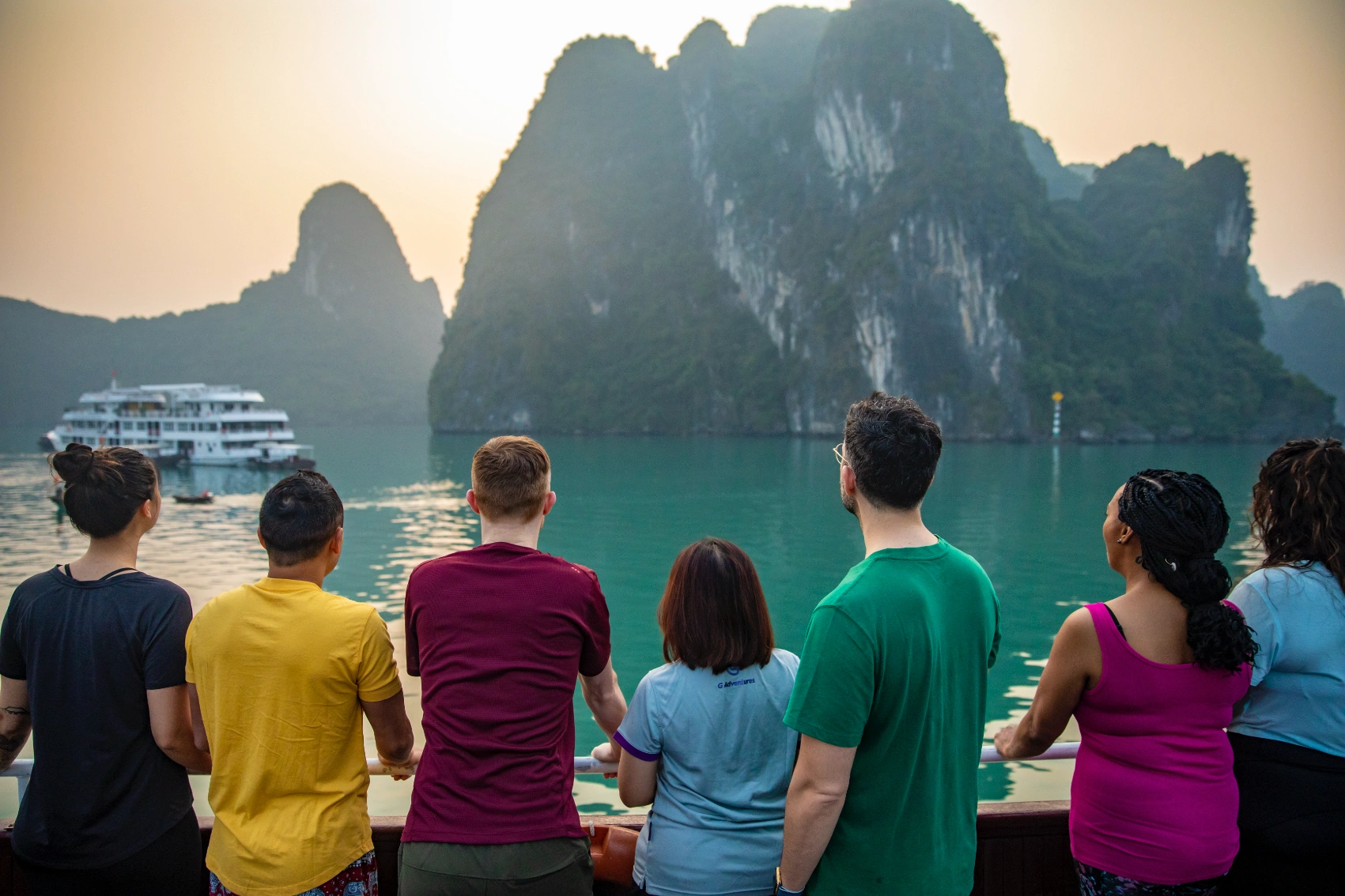 A group of travellers looks at a boat in Halong Bay, Vietnam