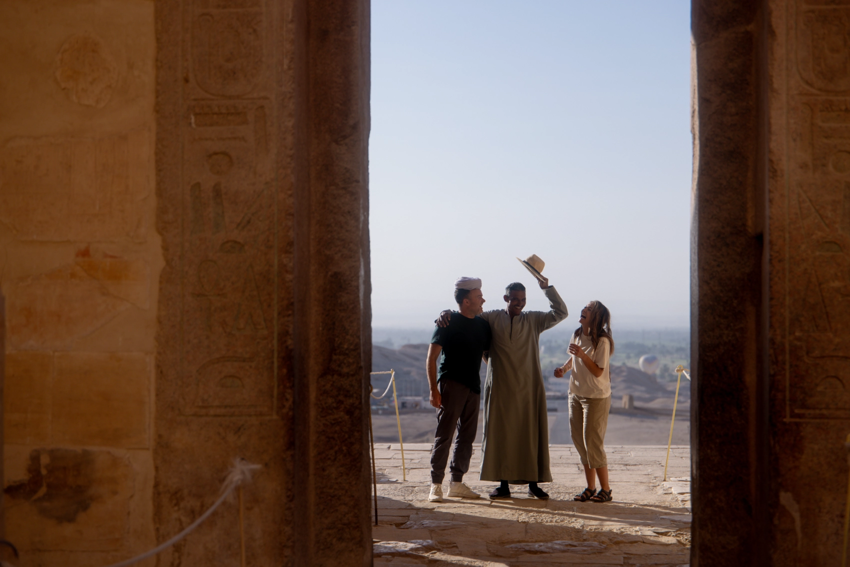 Travellers trade hats with a temple guardian in Luxor, Egypt