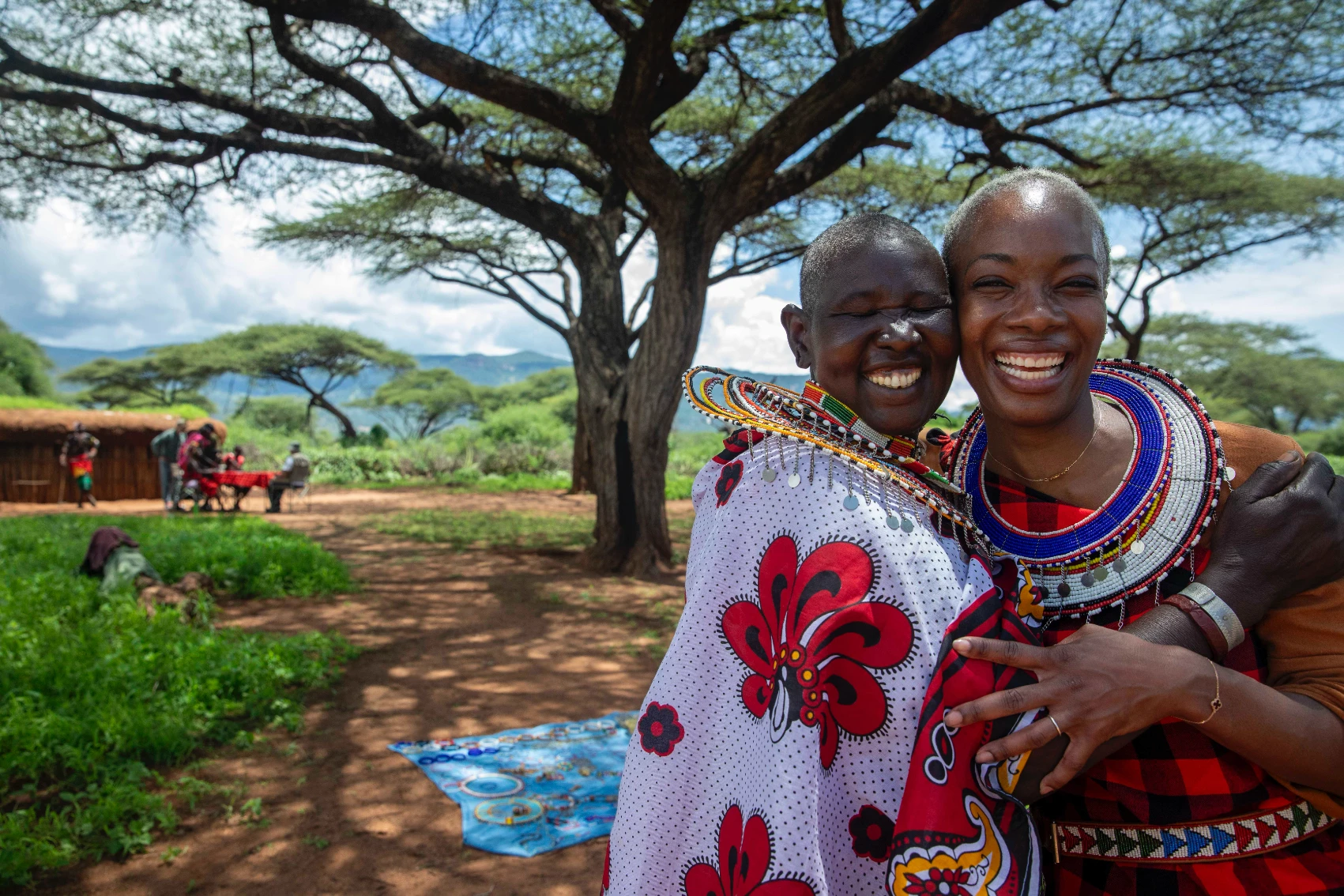 Two women in traditional dress on a sunny day in Kenya