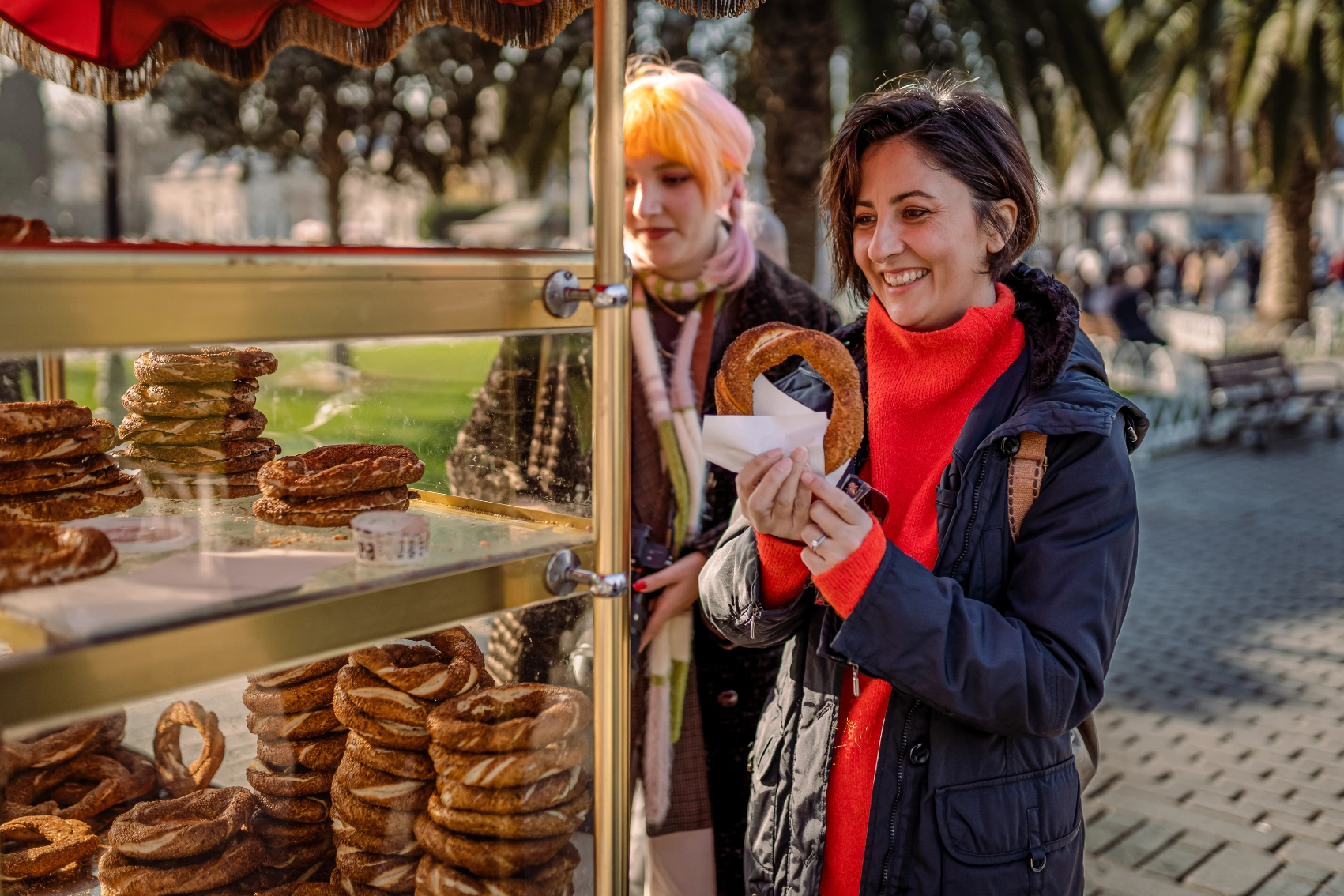 A woman traveller buys simit from a cart on the street in Turkey