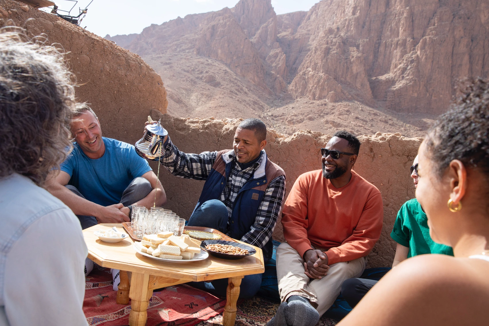 Cultural tour in Morocco A Moroccan man pours tea for a group of travellers