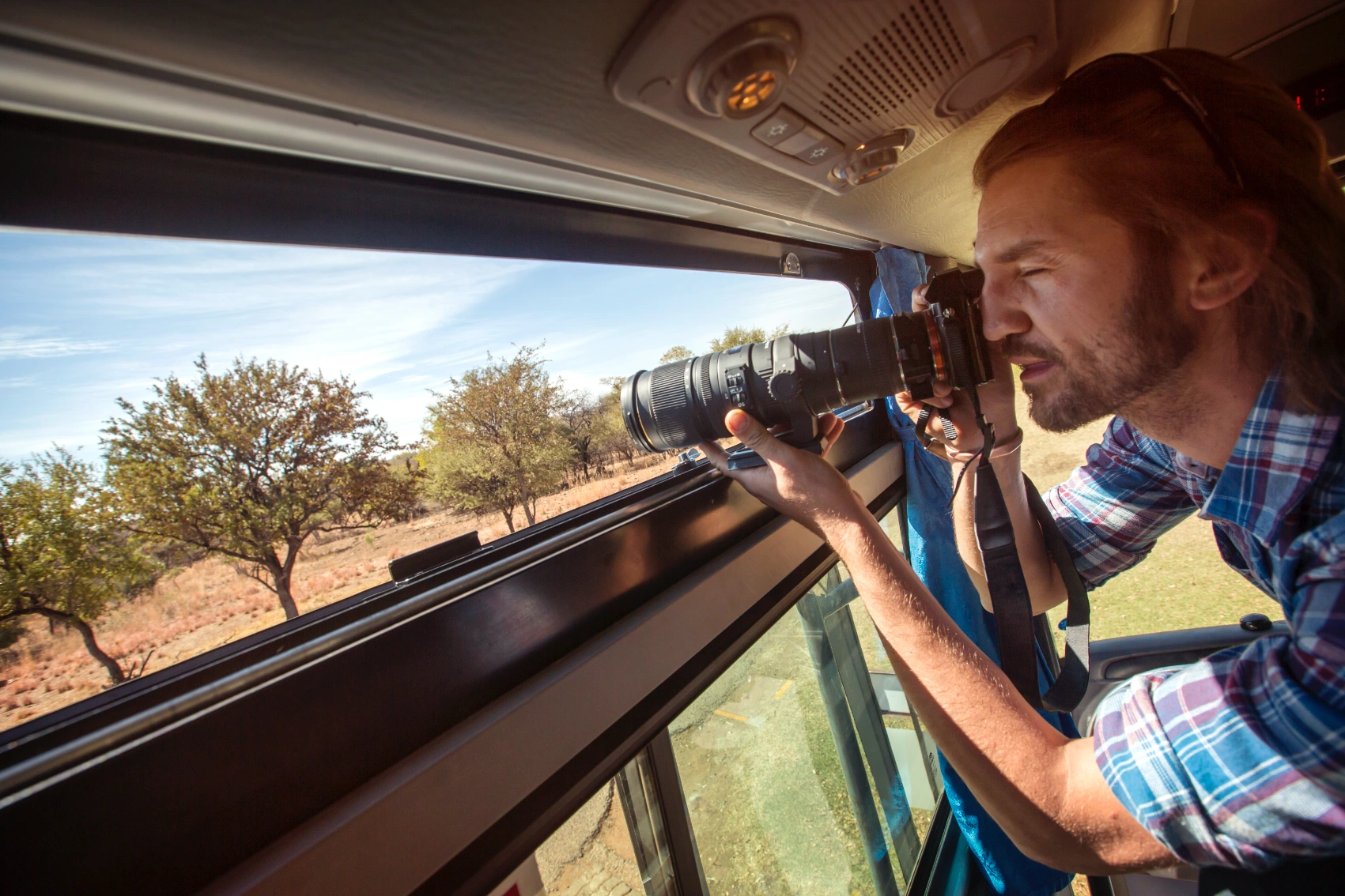 Overland safari, Africa A traveller takes a photo from the window of the G Adventures Lando in Africa