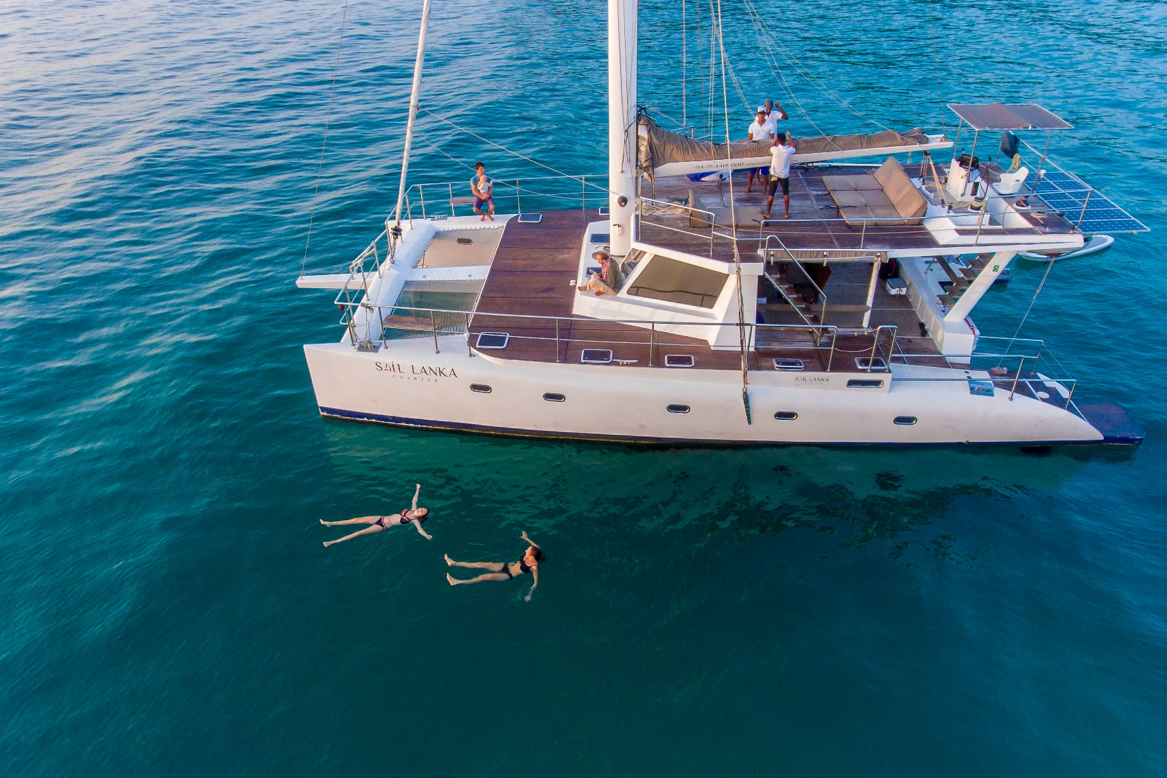 Sri Lanka sailing with G Adventures Two travellers swim next to a G Adventures sailboat in Sri Lanka