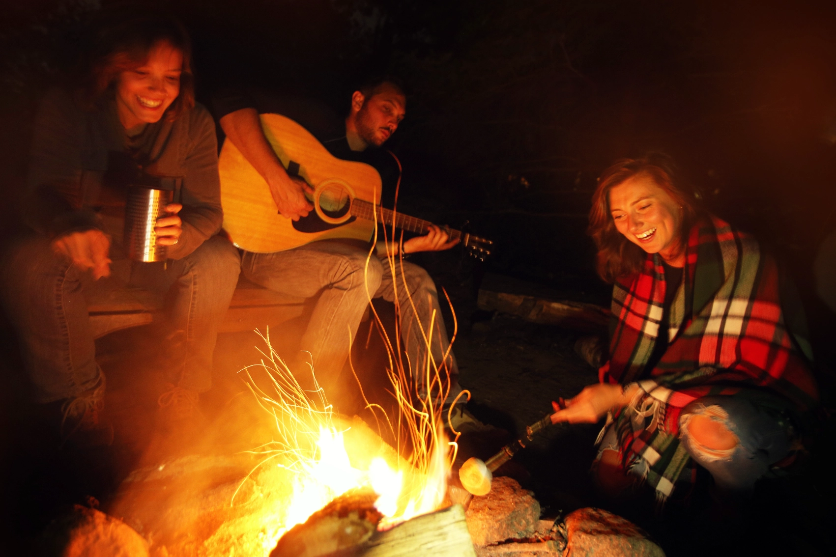 A group of travellers sits around a campfire in Canada