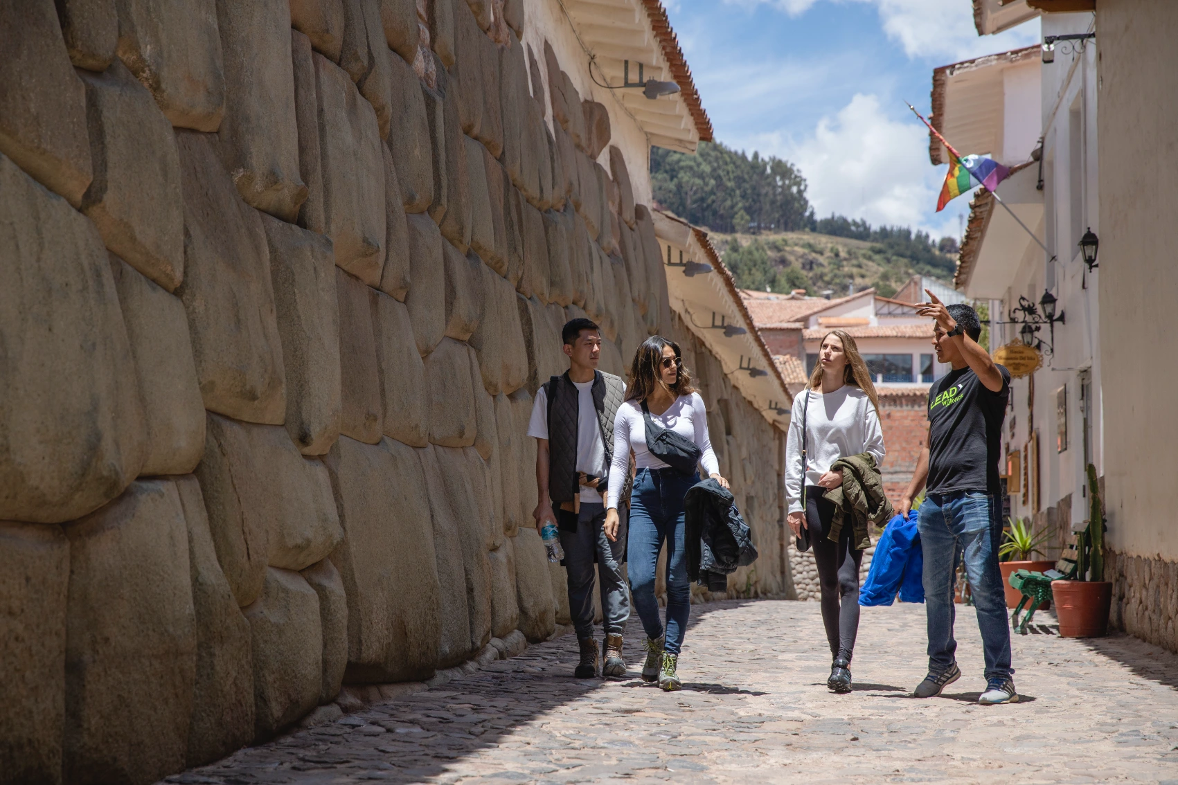 A small group of travellers follows a tour guide in Peru