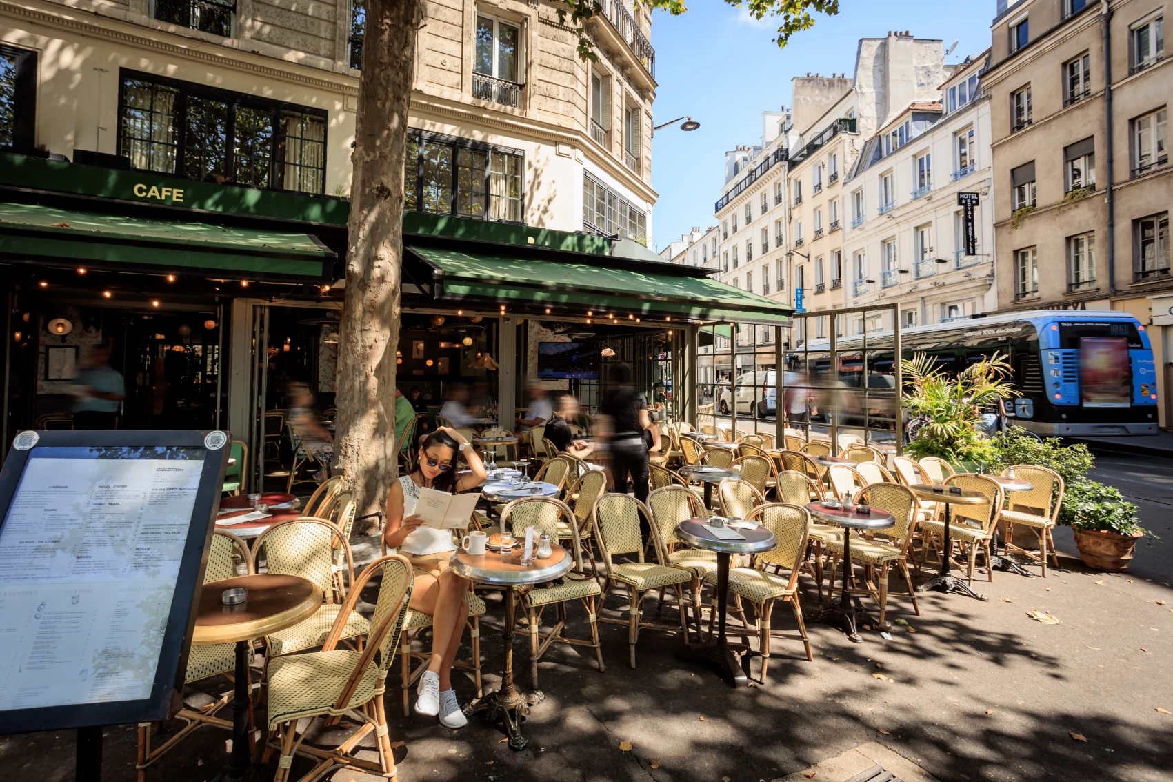 Sidewalk café in Paris, France A woman traveller looks at a menu at a sidewalk café in Paris, France