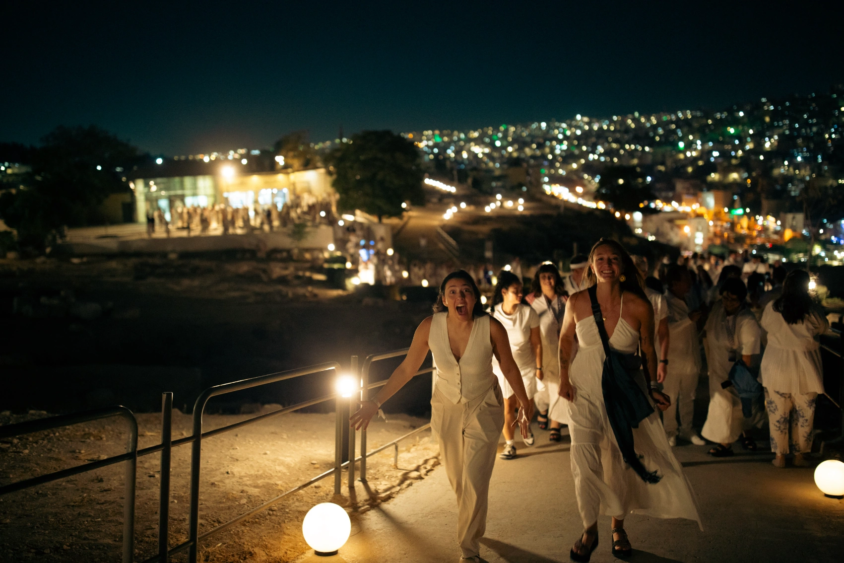 GX event in Jordan A group of travellers walks by Roman ruins at night in Jordan
