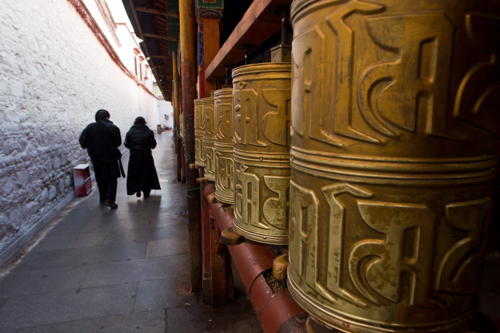 Two people walk past Ramoche Temple in Lhasa, Tibet