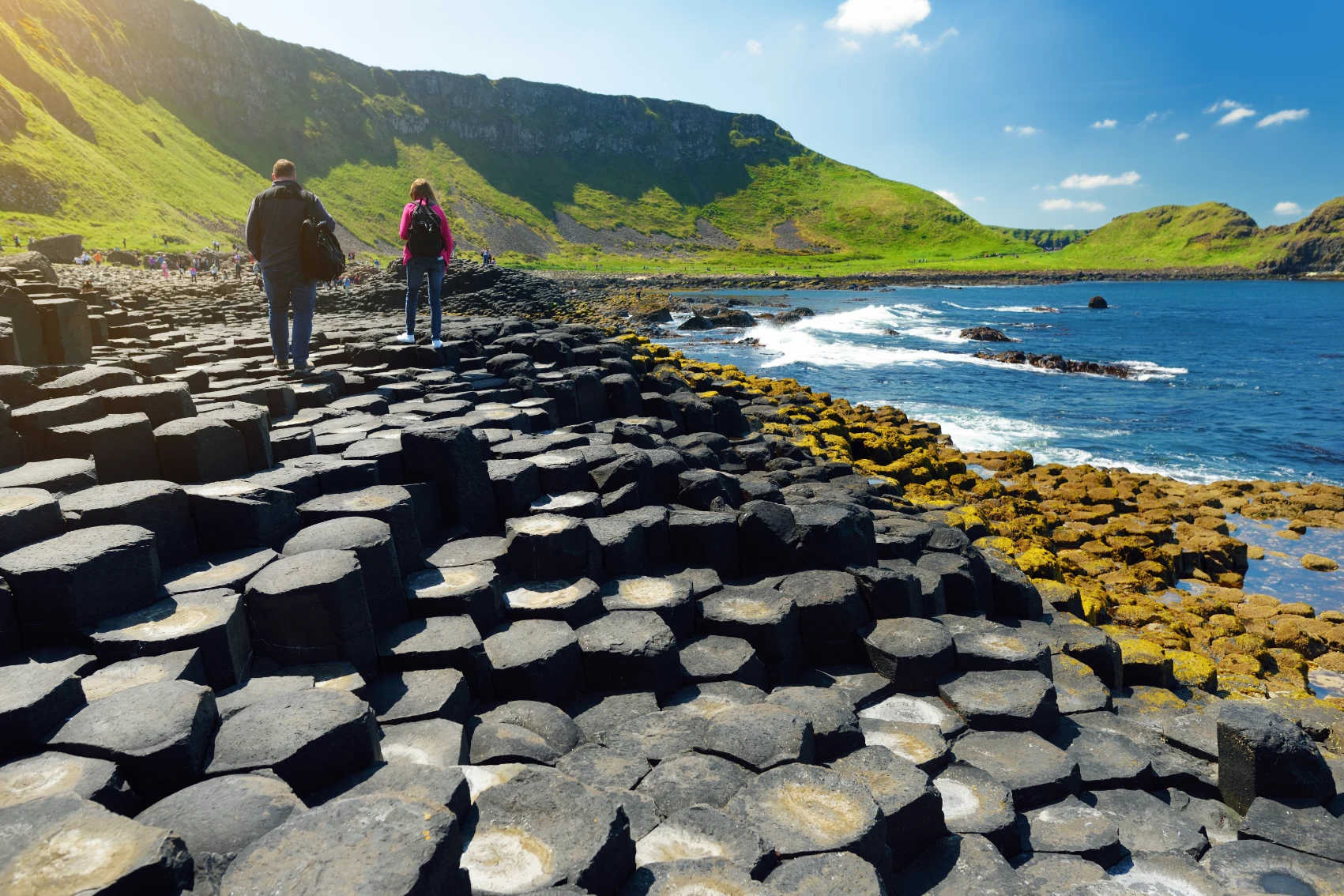 Two hikers walk on the basalt formations of the Giant's Causeway in Northern Ireland