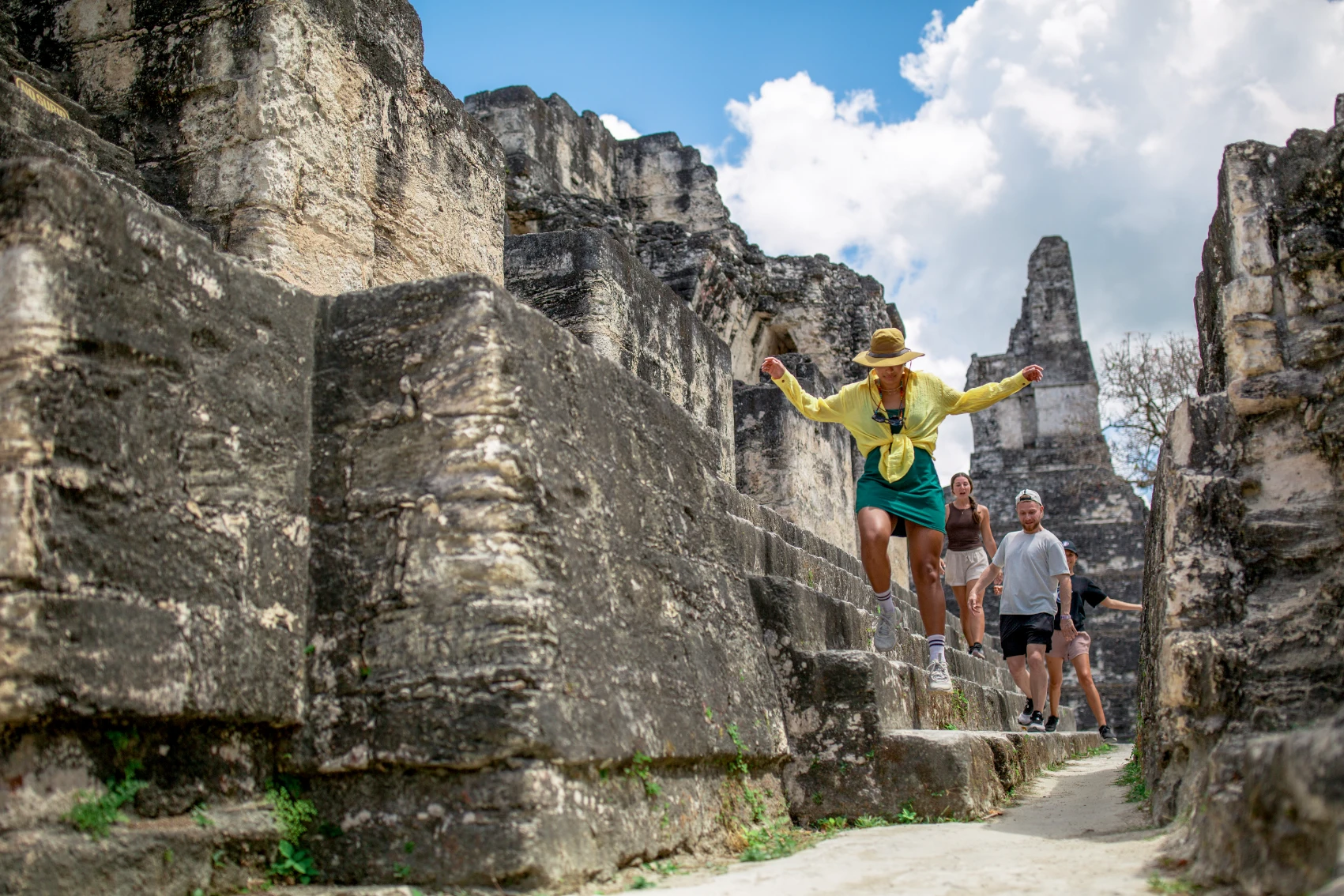 A group of travellers walks through the ruins of Tikal in Guatemala