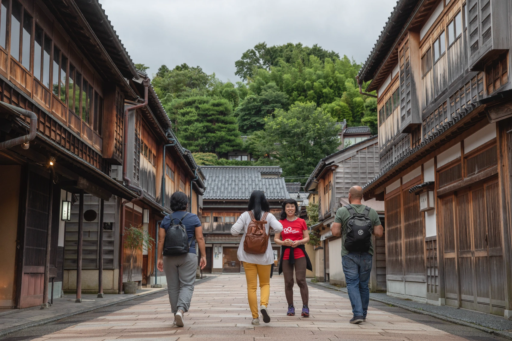 A group of travellers walks through a traditional village in Japan