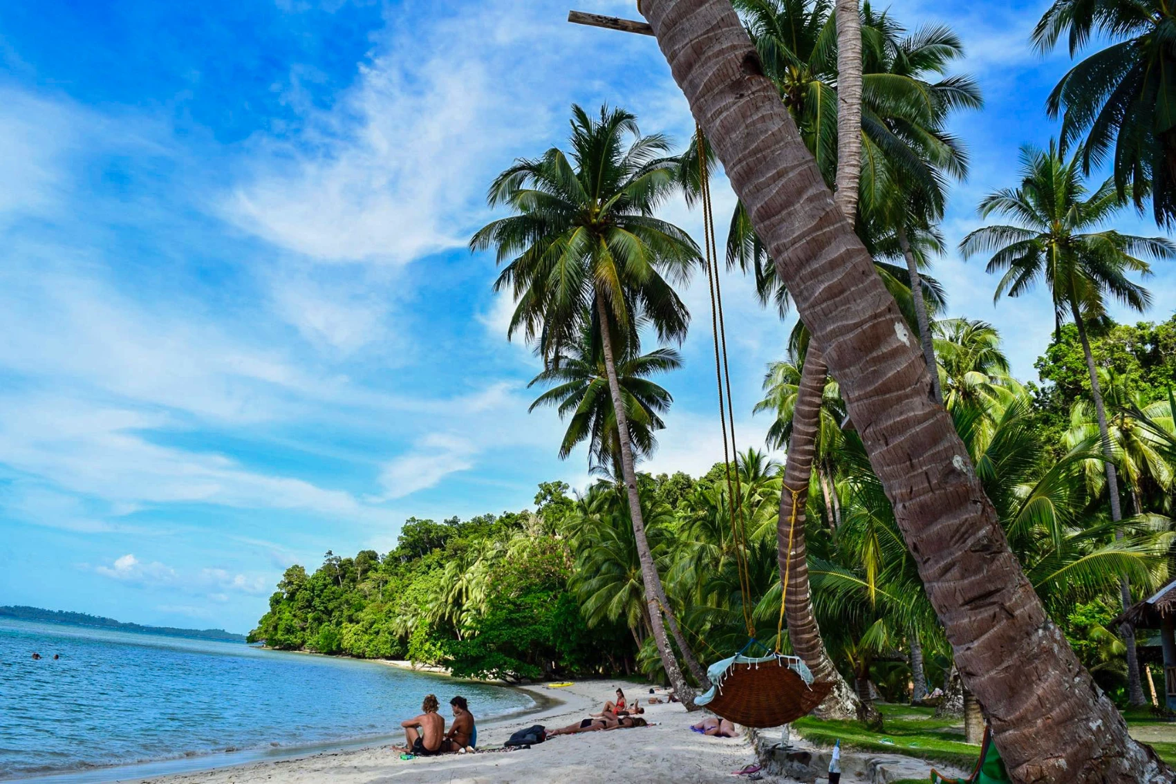 Two travellers relax on an otherwise empty beach in the Philippines