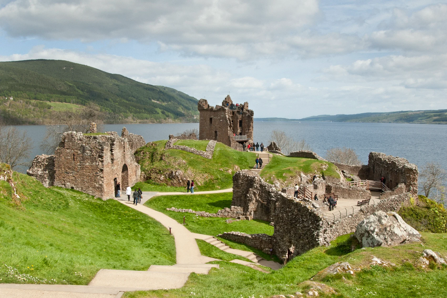 Loch Ness, Scotland Travellers walking around the ruins of Urquhart Castle overlooking Loch Ness, Scotland