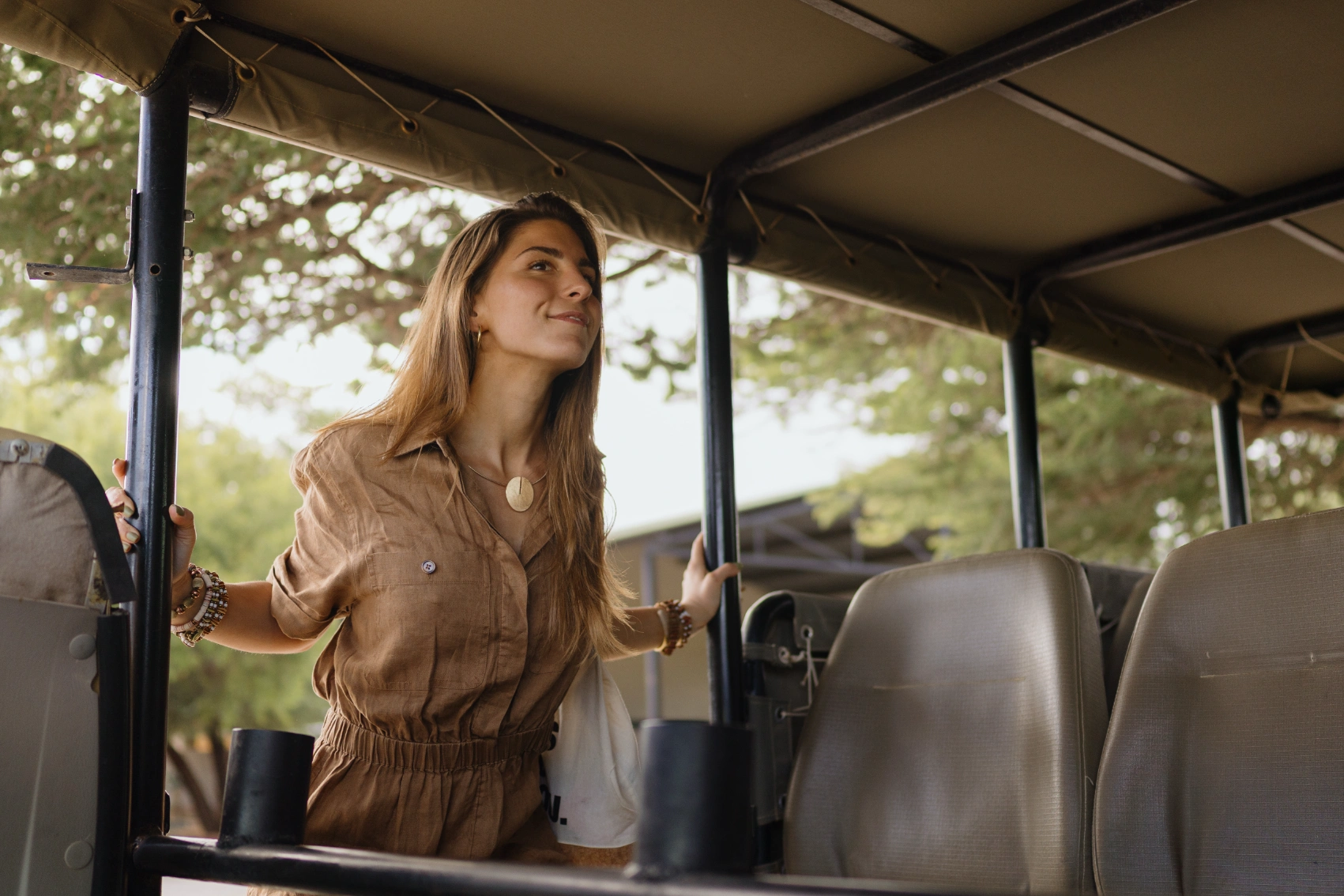 A woman traveller gets into a safari car in Kruger National Park, South Africa