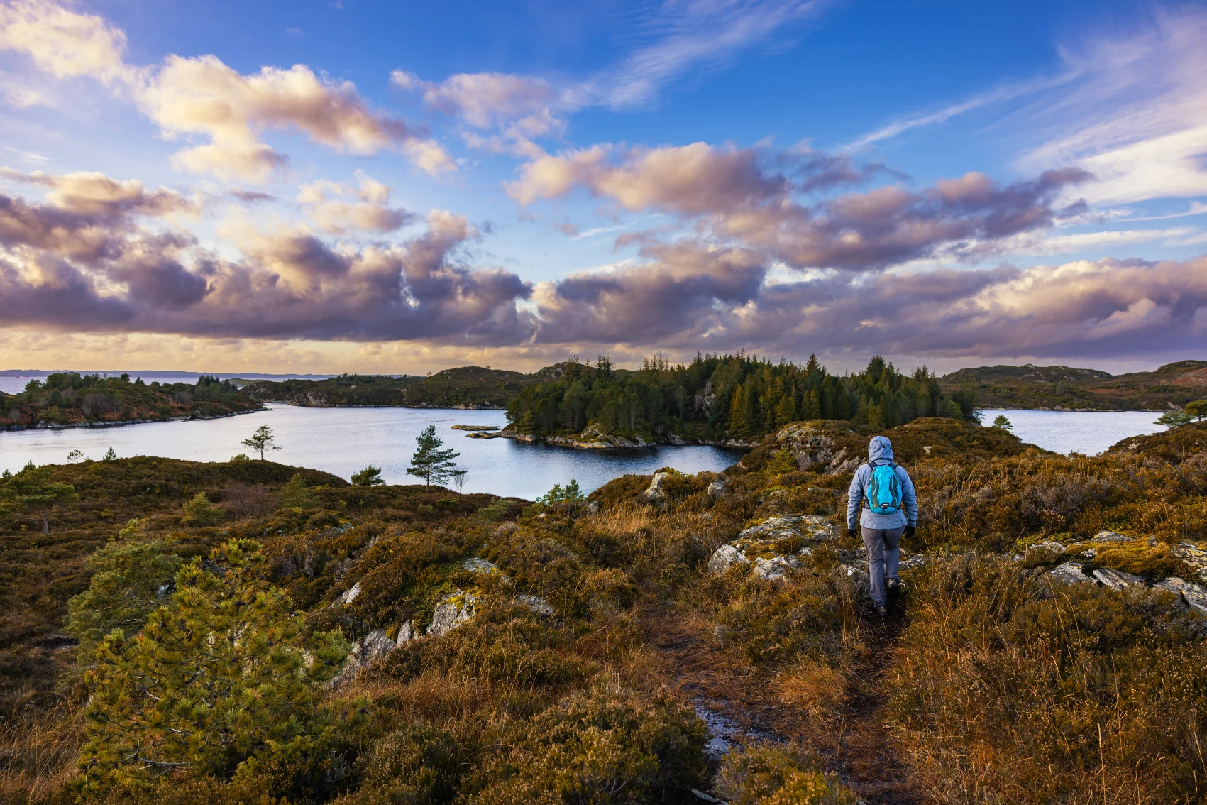 A woman traveller hikes towards fjords near Bergen, Norway