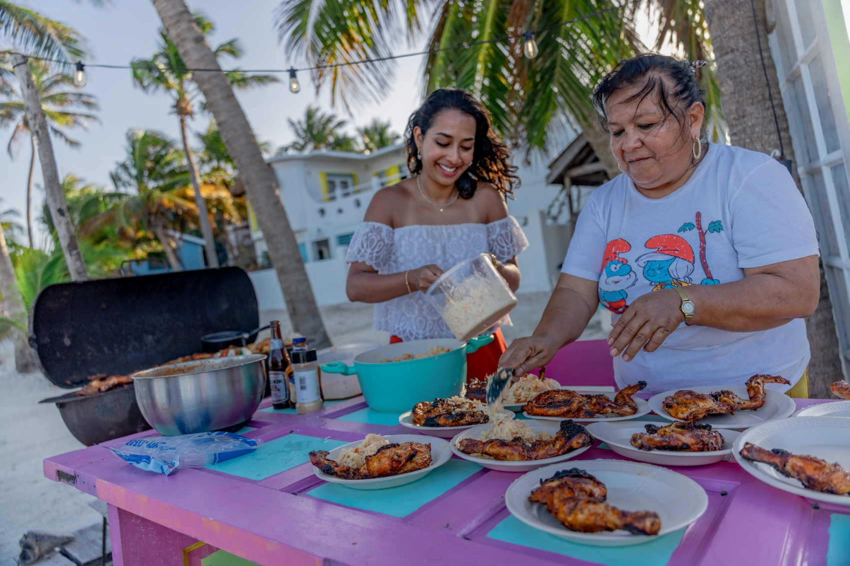 Two women cook at a grill in Belize