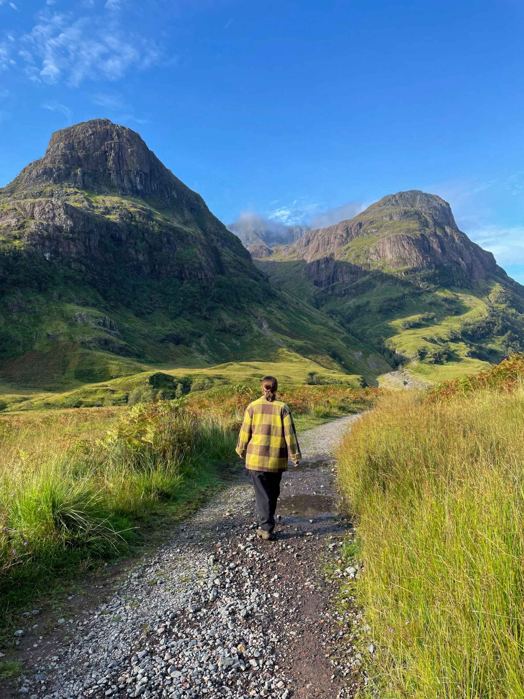 A woman walks through a glen in the Highlands of Scotland