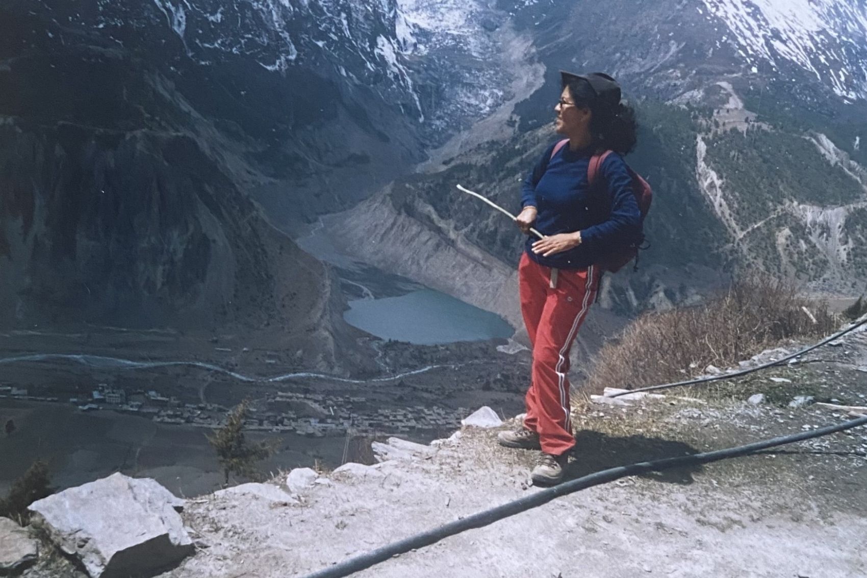 One of the three sisters trekking guides standing on top of a mountain in Nepal