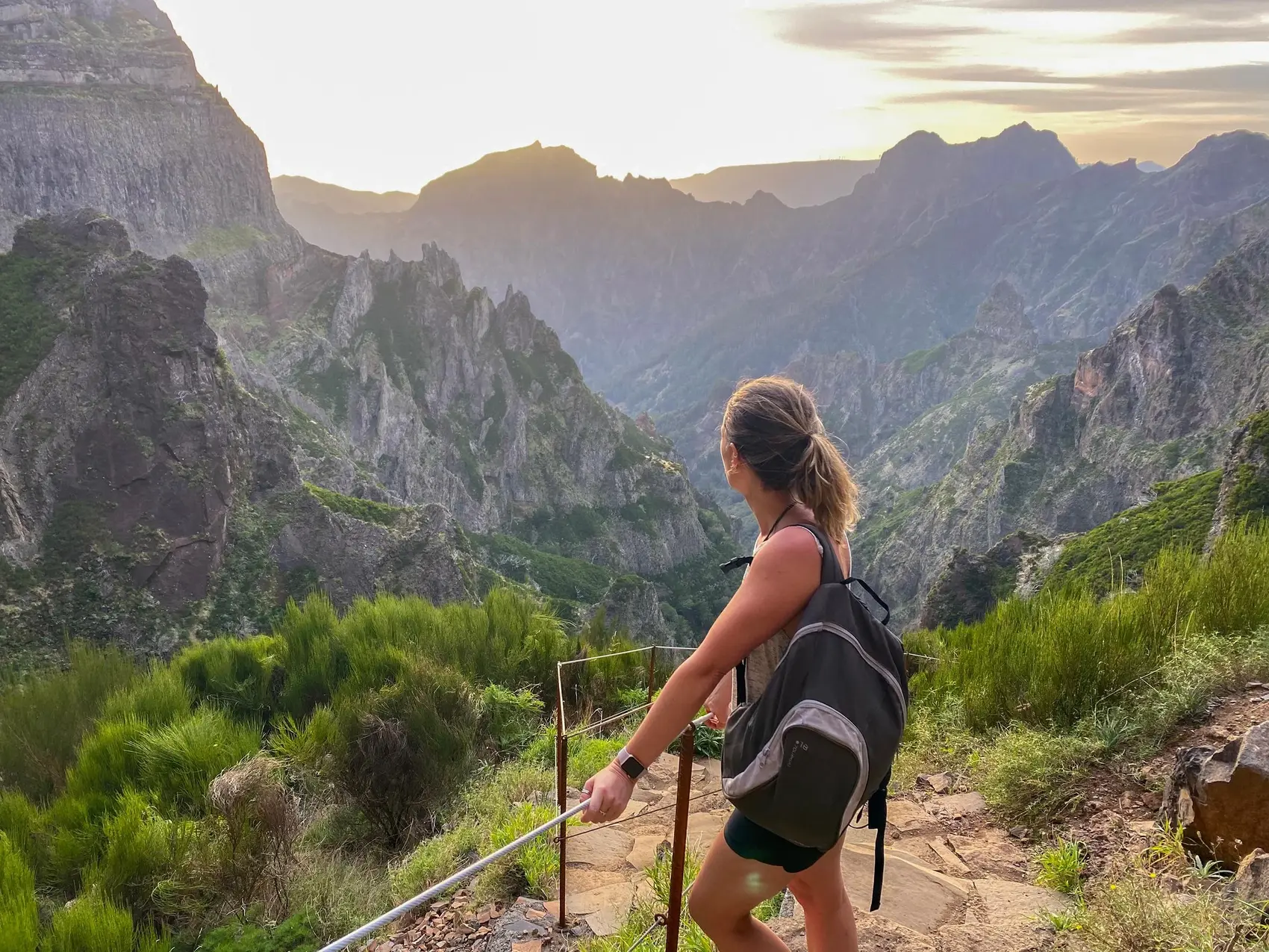 Woman standing in front of a viewpoint at sunset in Madeira