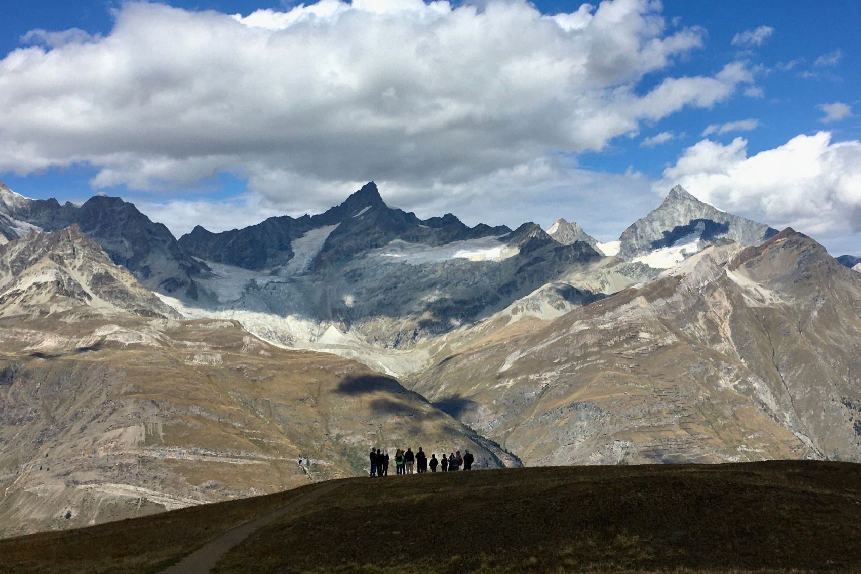 A group of travellers standing in front of mountains in Switzerland