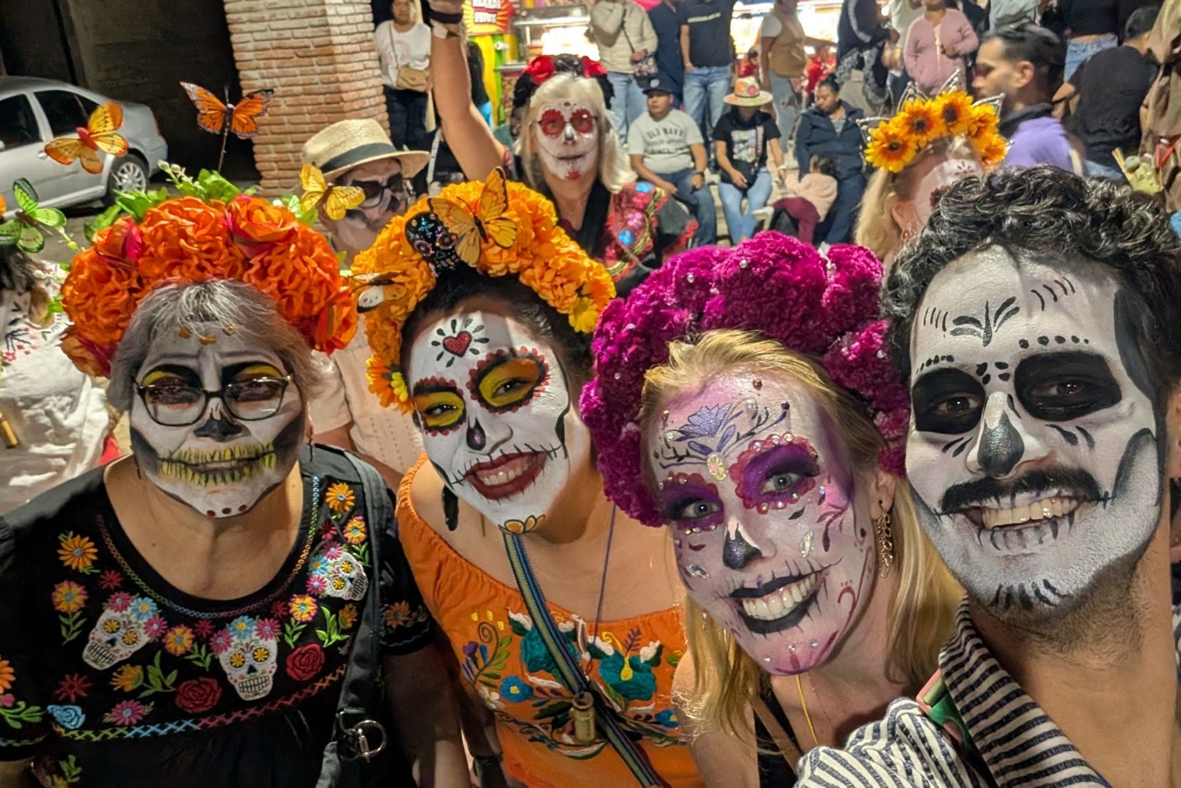Four people smiling at the Day of the Dead festival in Oaxaca, Mexico