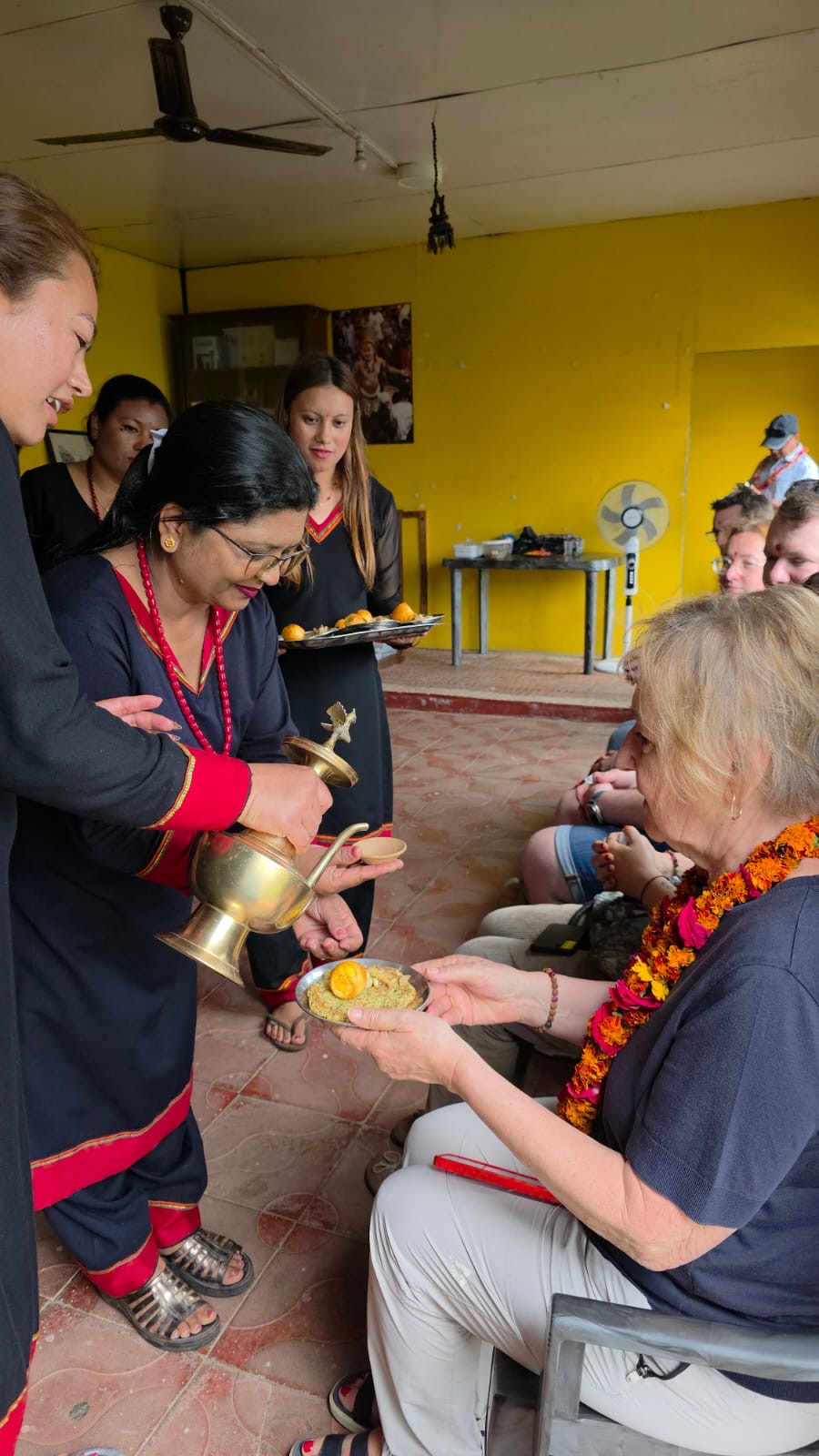 A lady at the Panauti homestay serving some travellers some tea in Nepal