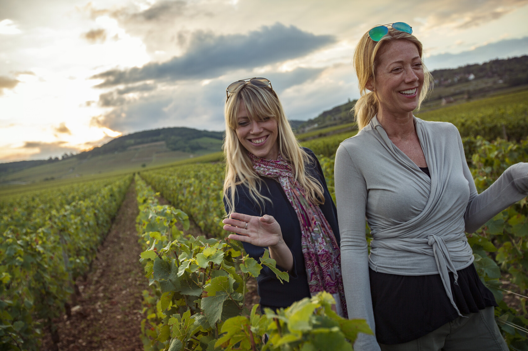Two women in the vineyards of France at sunset