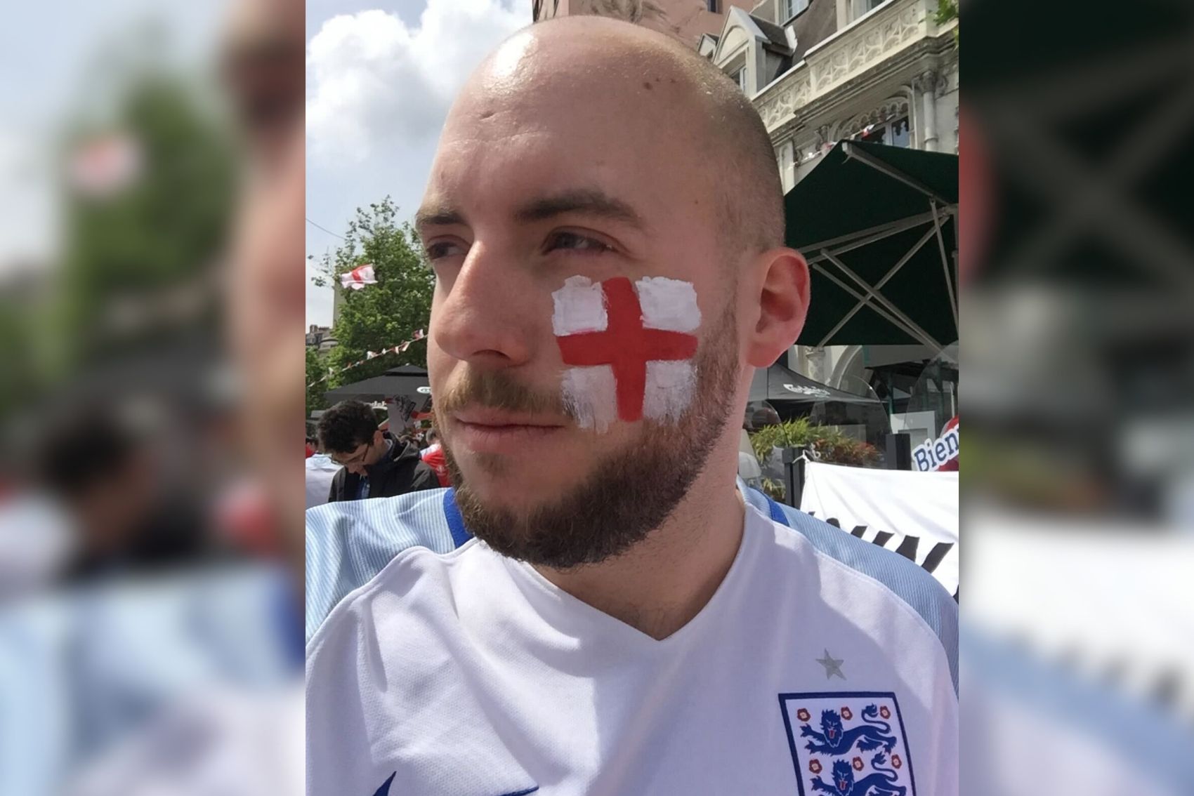Joseph Speckman posing for a photograph with an England flag painted on his face at the football