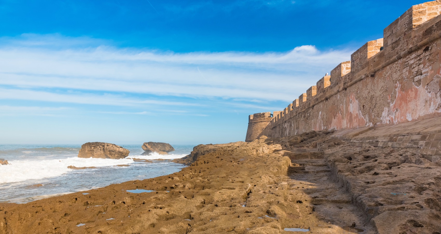 The beach and city walls outside Essaouira in Morocco - Leamus