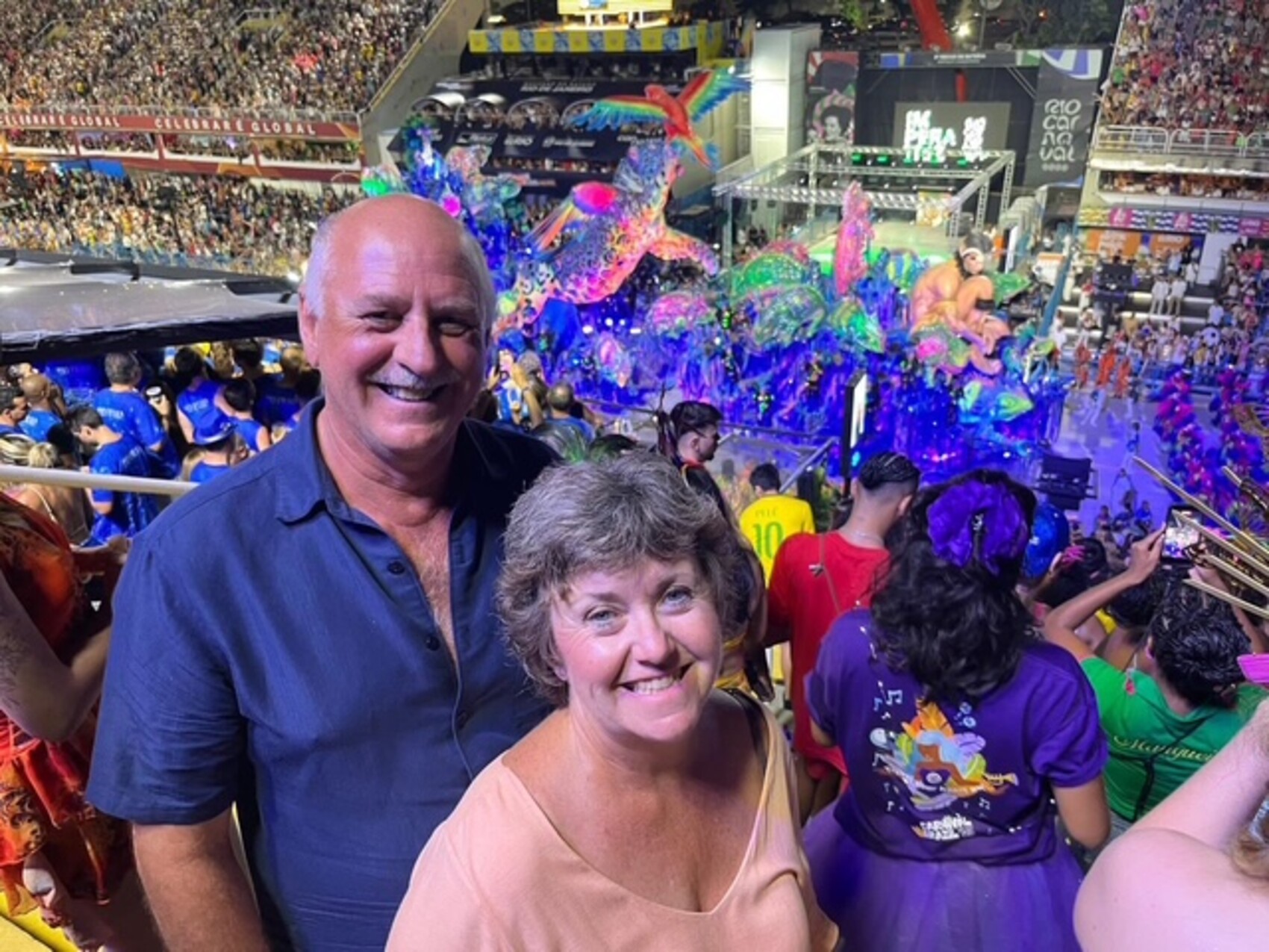 Judy and Blair a couple from Manitoba, Canada posing in front of parade at the Sambadrome in Rio de Janiero
