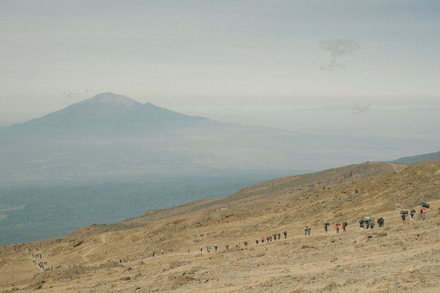 A line of people climbing up the slopes of Kilimanjaro