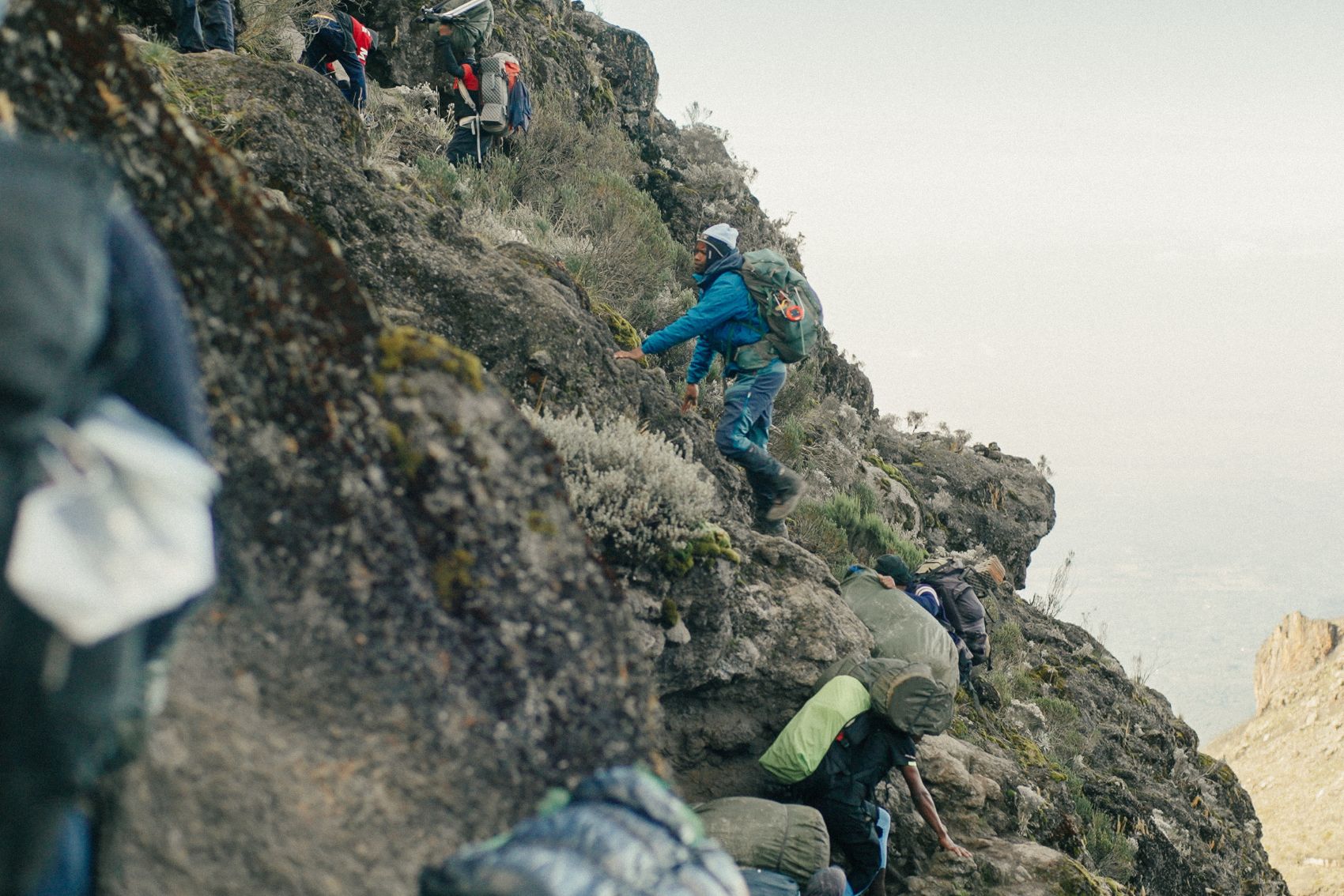 People scaling a rock face on Mt. Kilimanjaro in Tanzania
