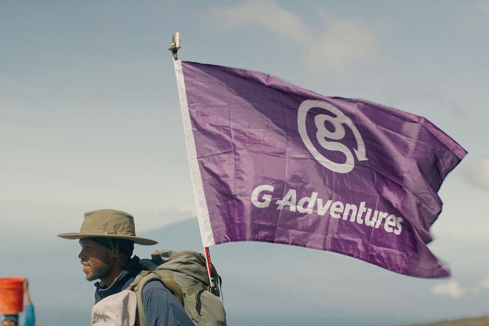 The G Adventures flag and a CEO on Mt. Kilimanjaro in Tanzania