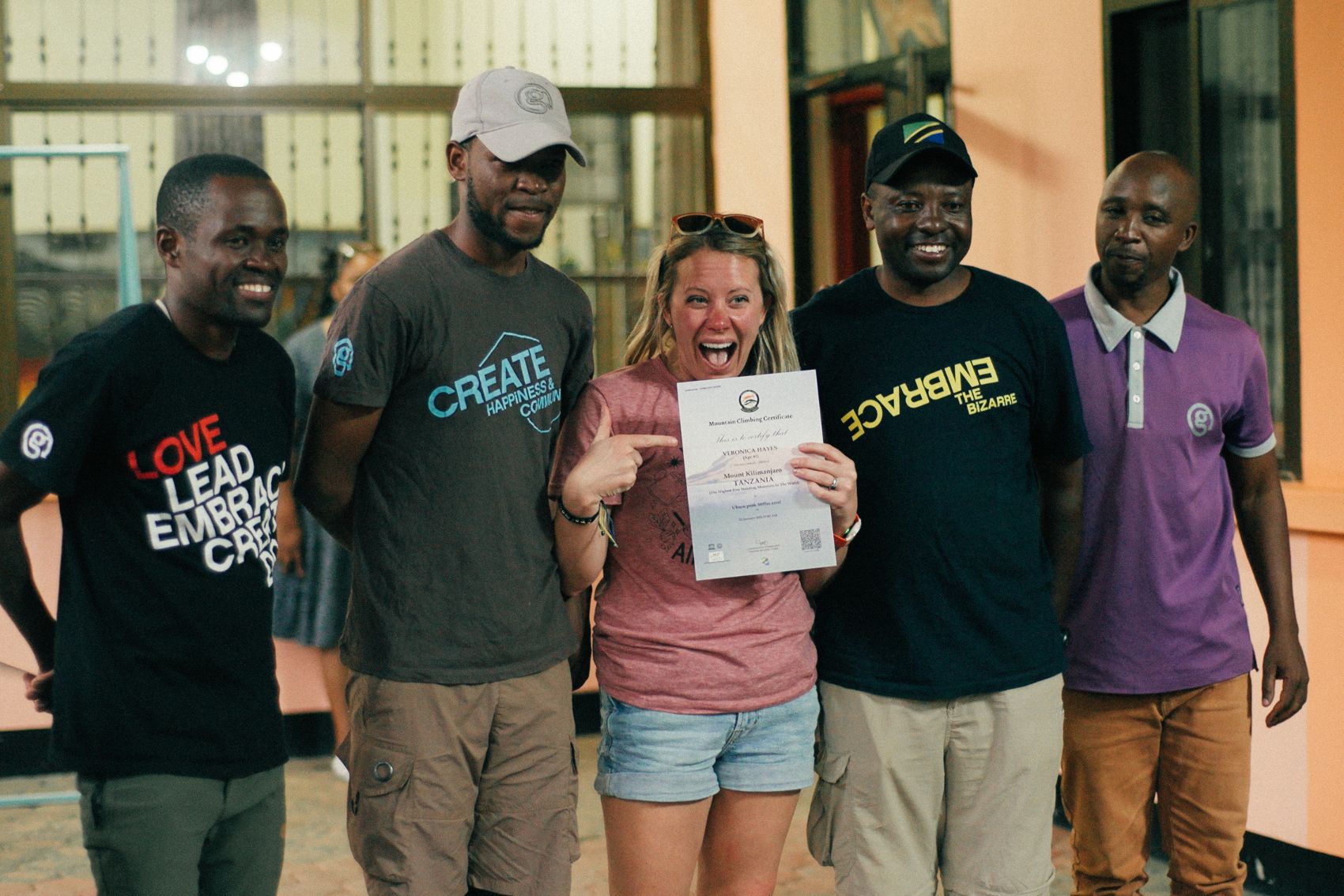 A person smiling with their CEOs after completing their Mt. Kilimanjaro tour