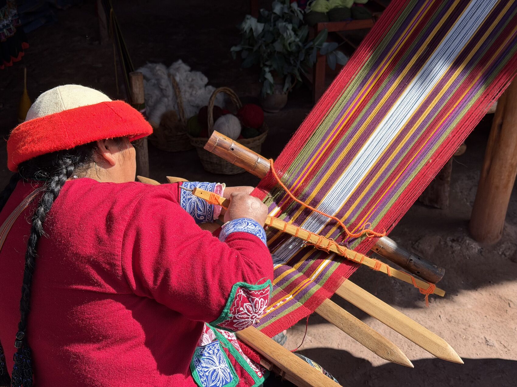 An indigenous woman weaving at the Ccaccaccollo community weaving workshop in Peru