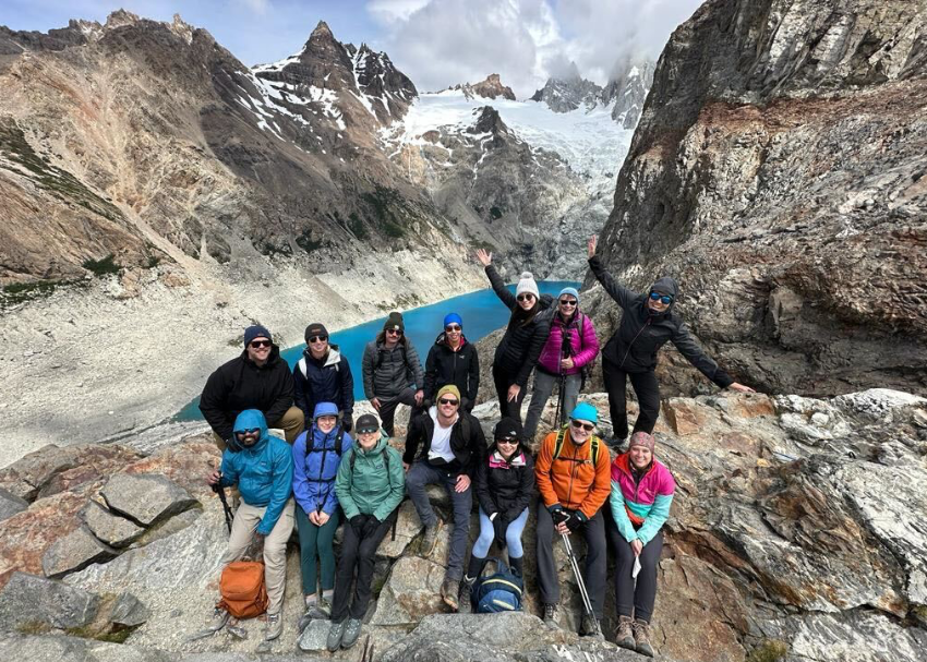 a happy and successful group of walkers from Patagonia celebrate with a group photo in the blue lagoon