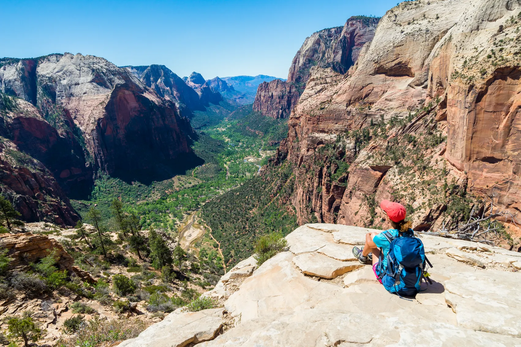 Angels Landing, Zion National Park A hiker sits on a rocky outcrop at the top of Angels Landing in Zion National Park, Utah