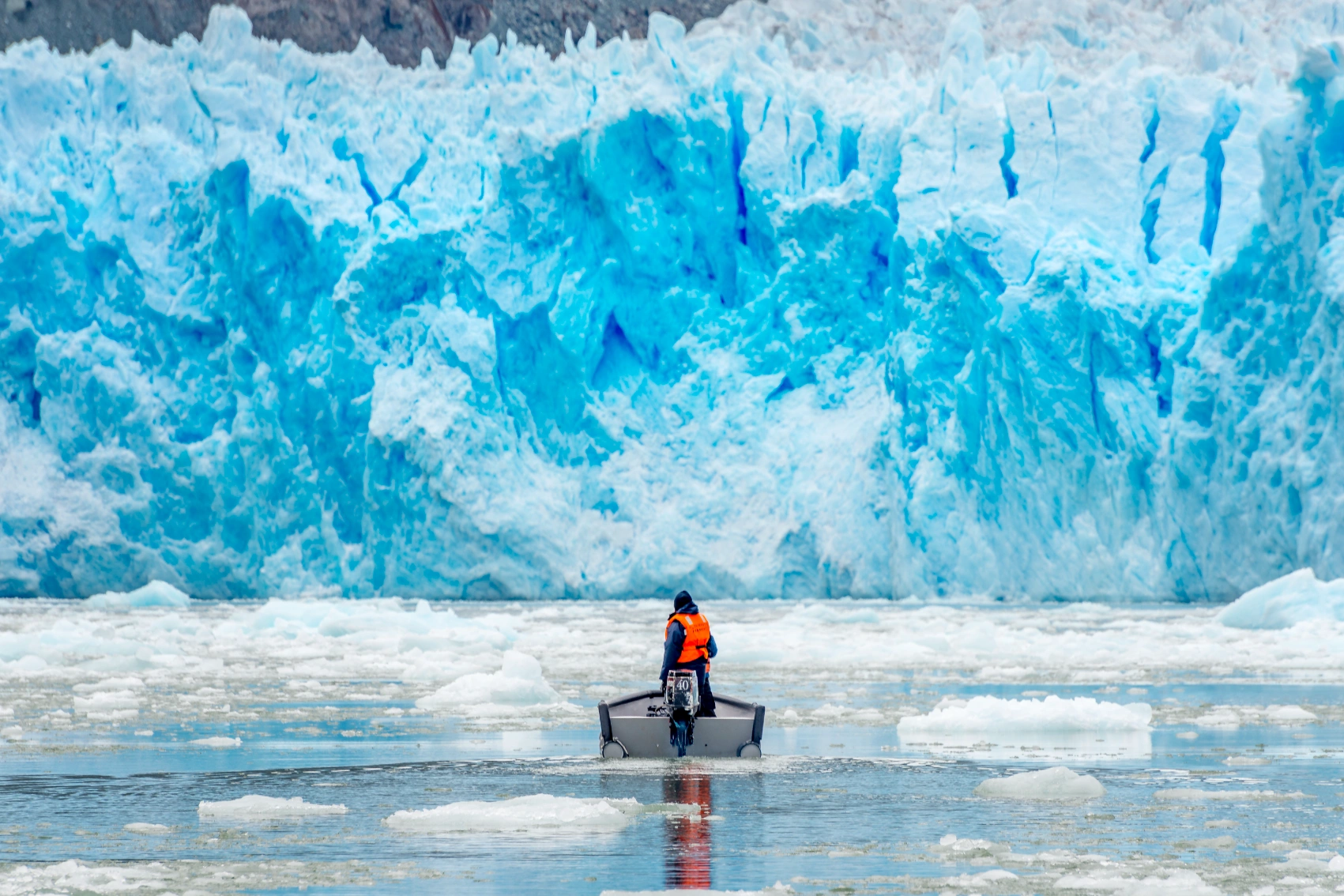 Winter in Alaska A person in a boat drives up to a glacier in Alaska