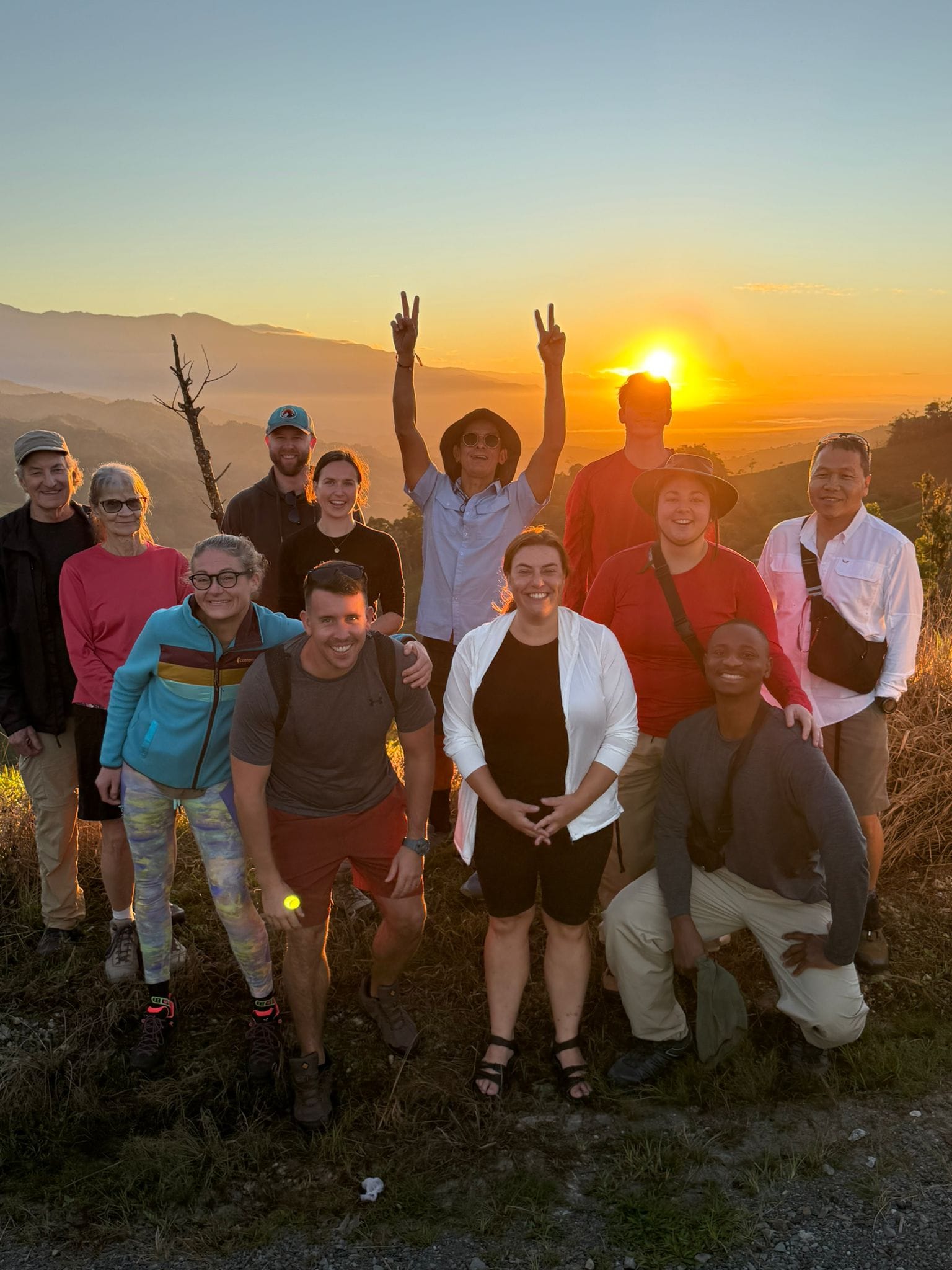 A group of travellers posing for a photograph at sunset in Costa Rica
