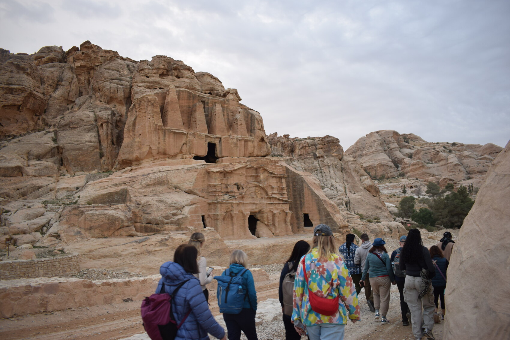 Ancient ruins with travellers walking by it in Jordan