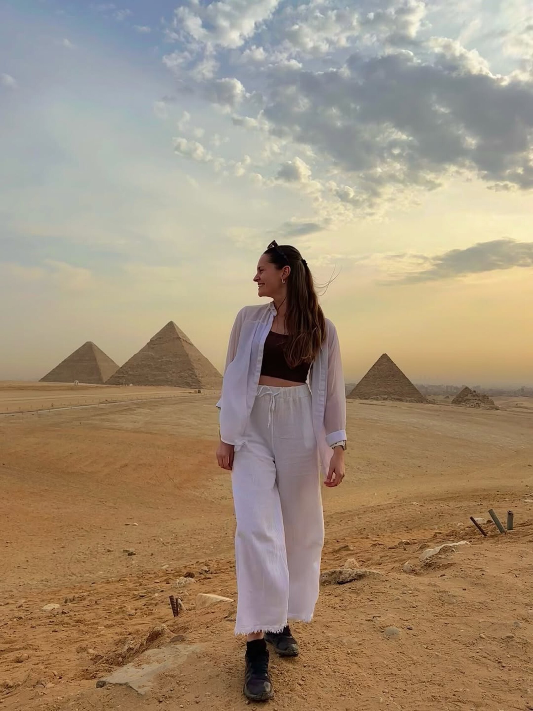 Swiss traveller Michelle Meyer posing for a picture in front of the Great Pyramids of Egypt