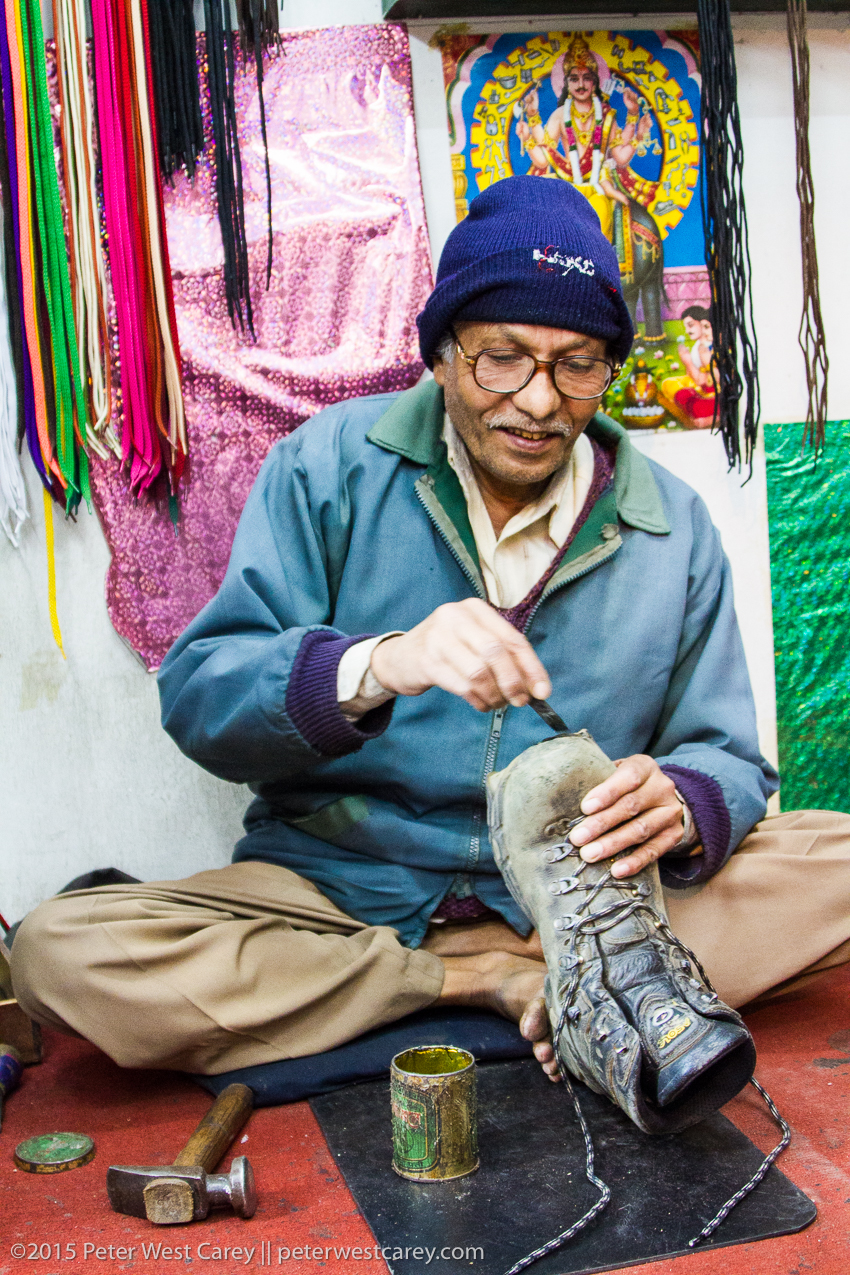 shoe repaireman smiling in bhutan.