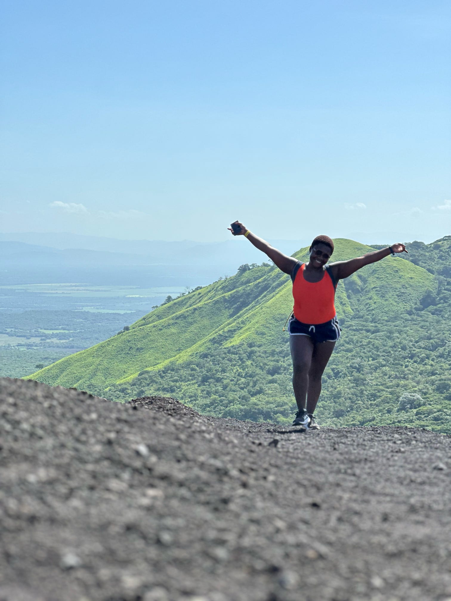 Ivy posing for a photograph in front of a volcano in Southeast Asia