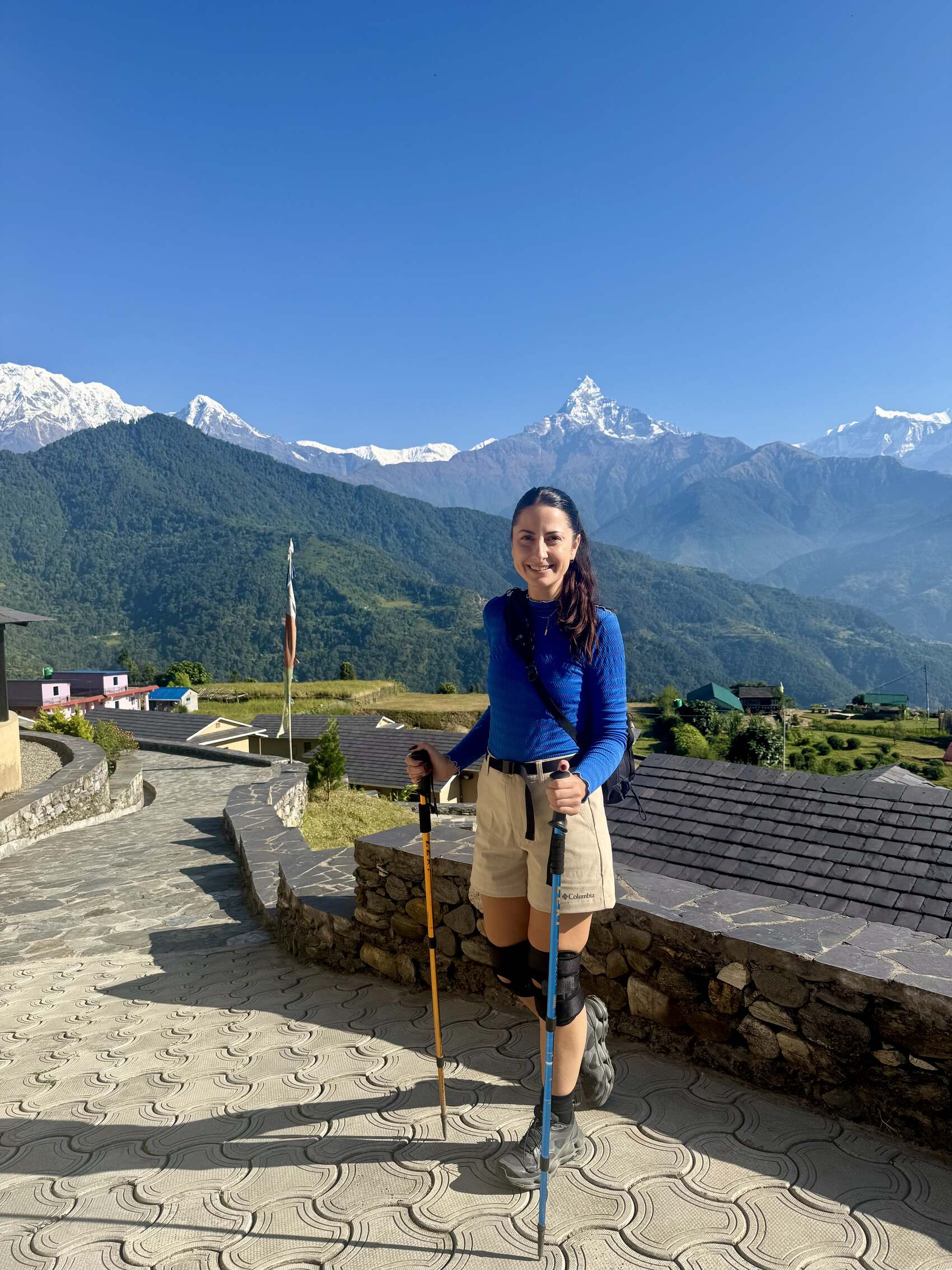 Raeann Watt standing in front of the towering peak of Annapurna in Nepal pre-hike