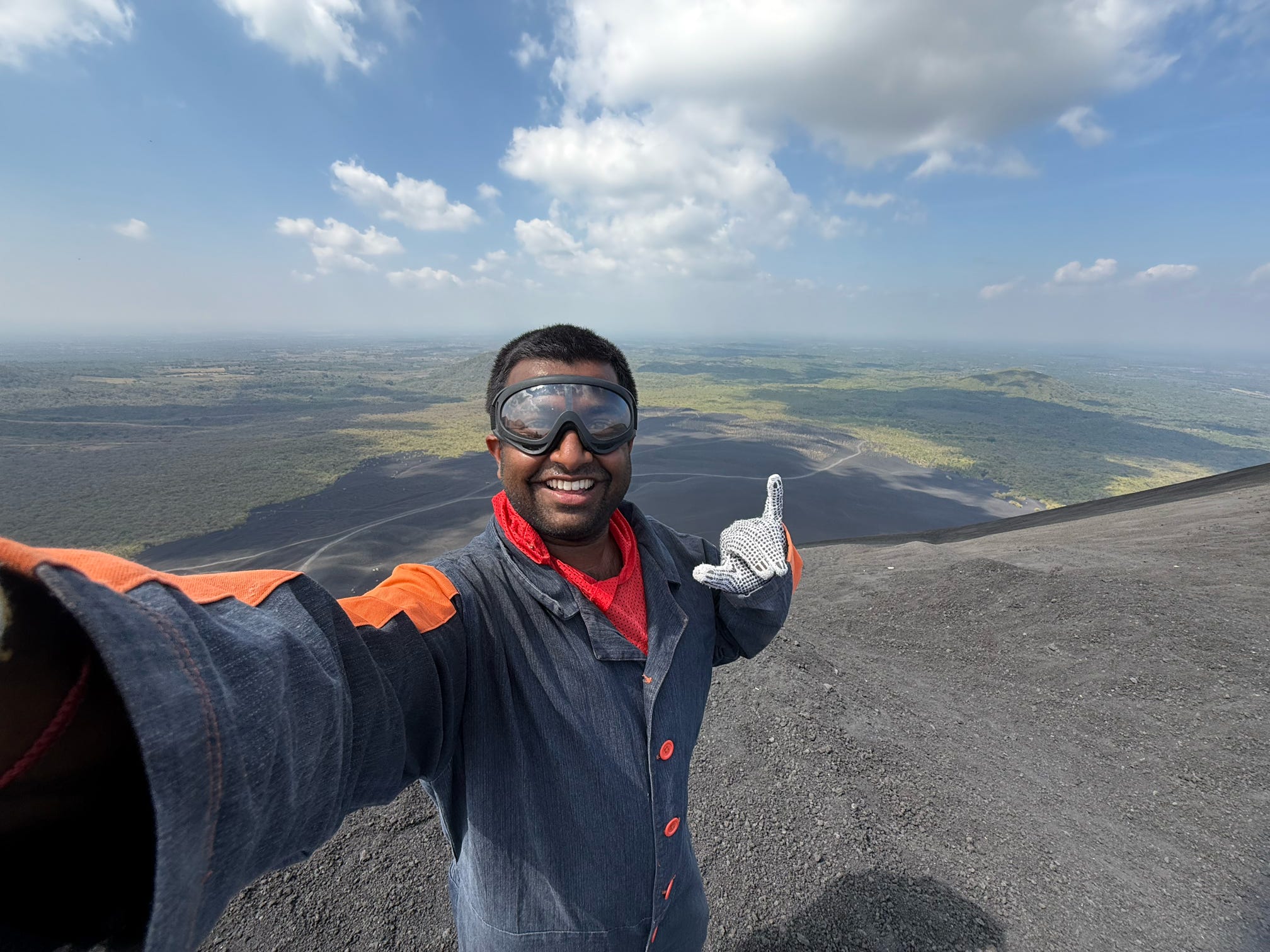 Ritesh Maharaj posing for a picture in front of a volcano in Central America
